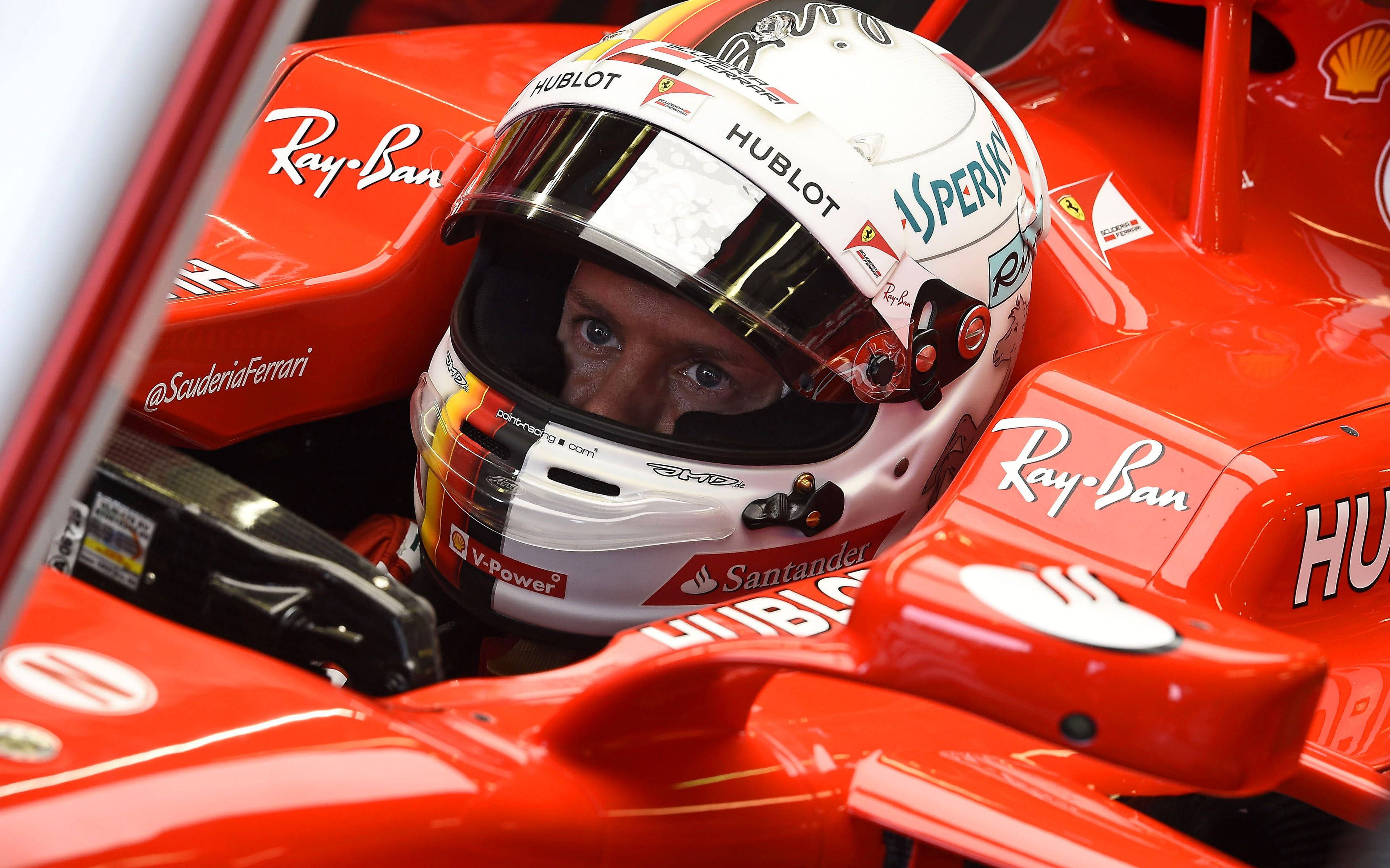 sebastian vettel 桌布 壁紙 — 一級方程式車手在紅色法拉利駕駛艙內的近距離特寫，戴著帶有贊助商標誌的白色頭盔。