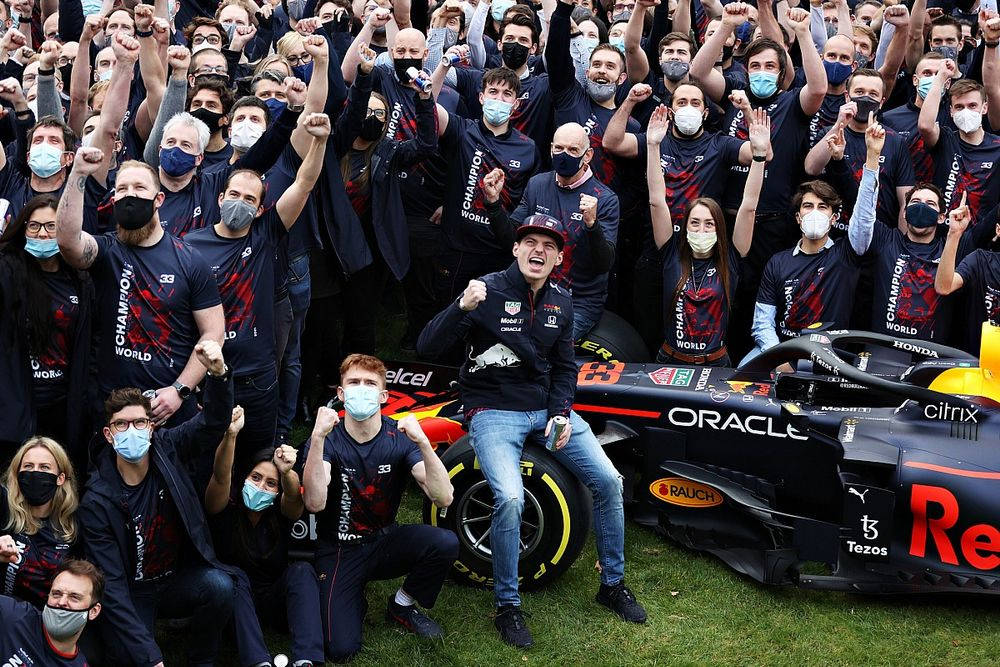F1車隊和車手在草地上舉起拳頭慶祝錦標賽勝利。 — 紅牛F1 壁紙