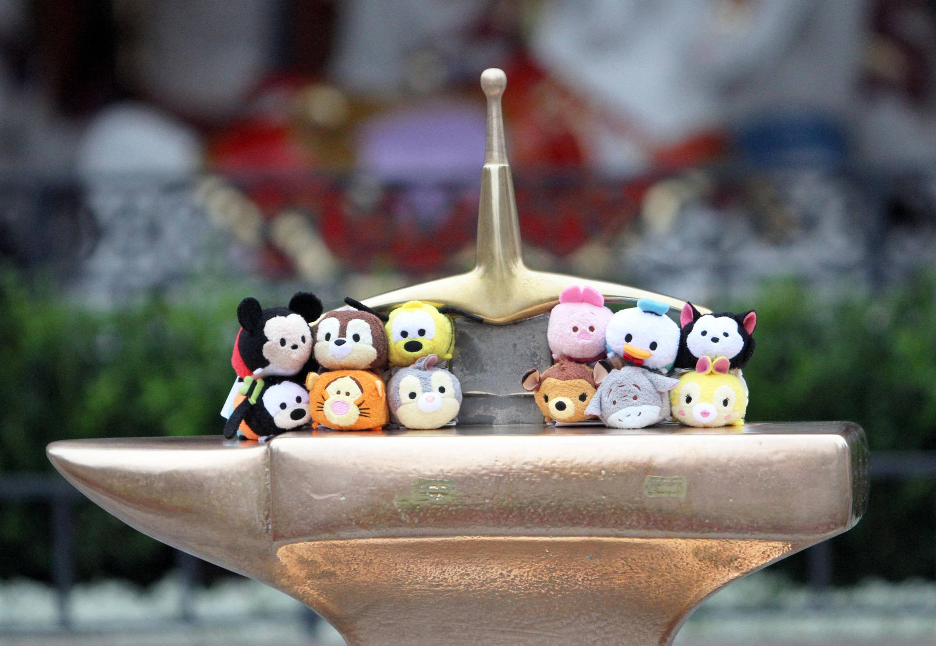 迪士尼 Tsum Tsum 毛絨公仔排列在公園的金色鐵砧上。 — Tsum tsum 壁紙