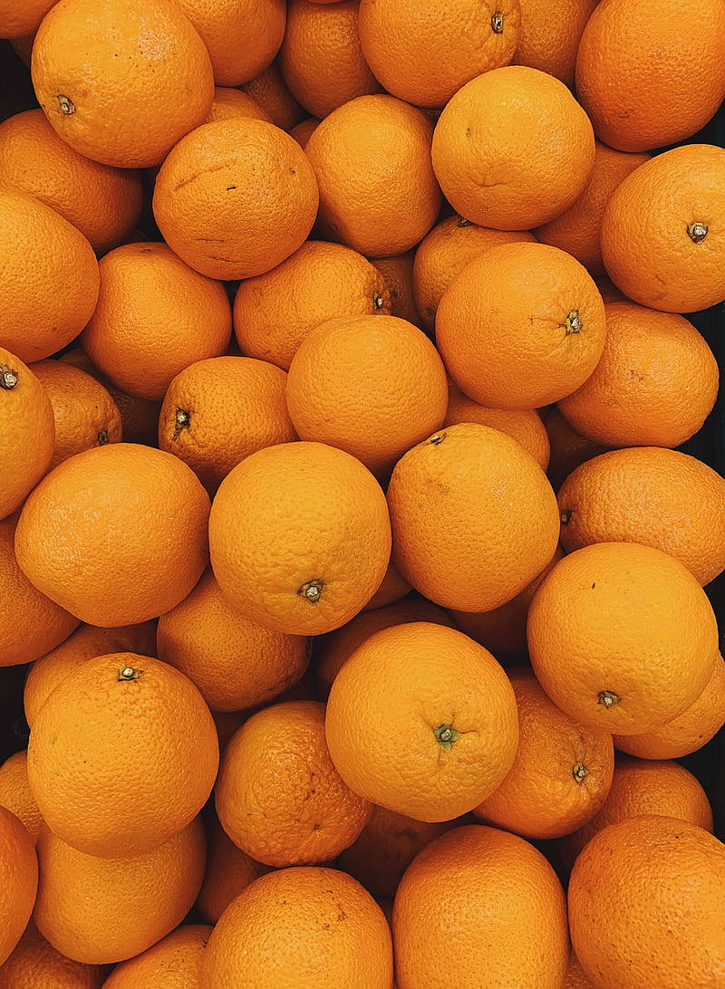 Fruit 桌布 壁紙 — 一組鮮豔橙色柑橘類水果的特寫照片，顯示出紋理果皮和莖端。