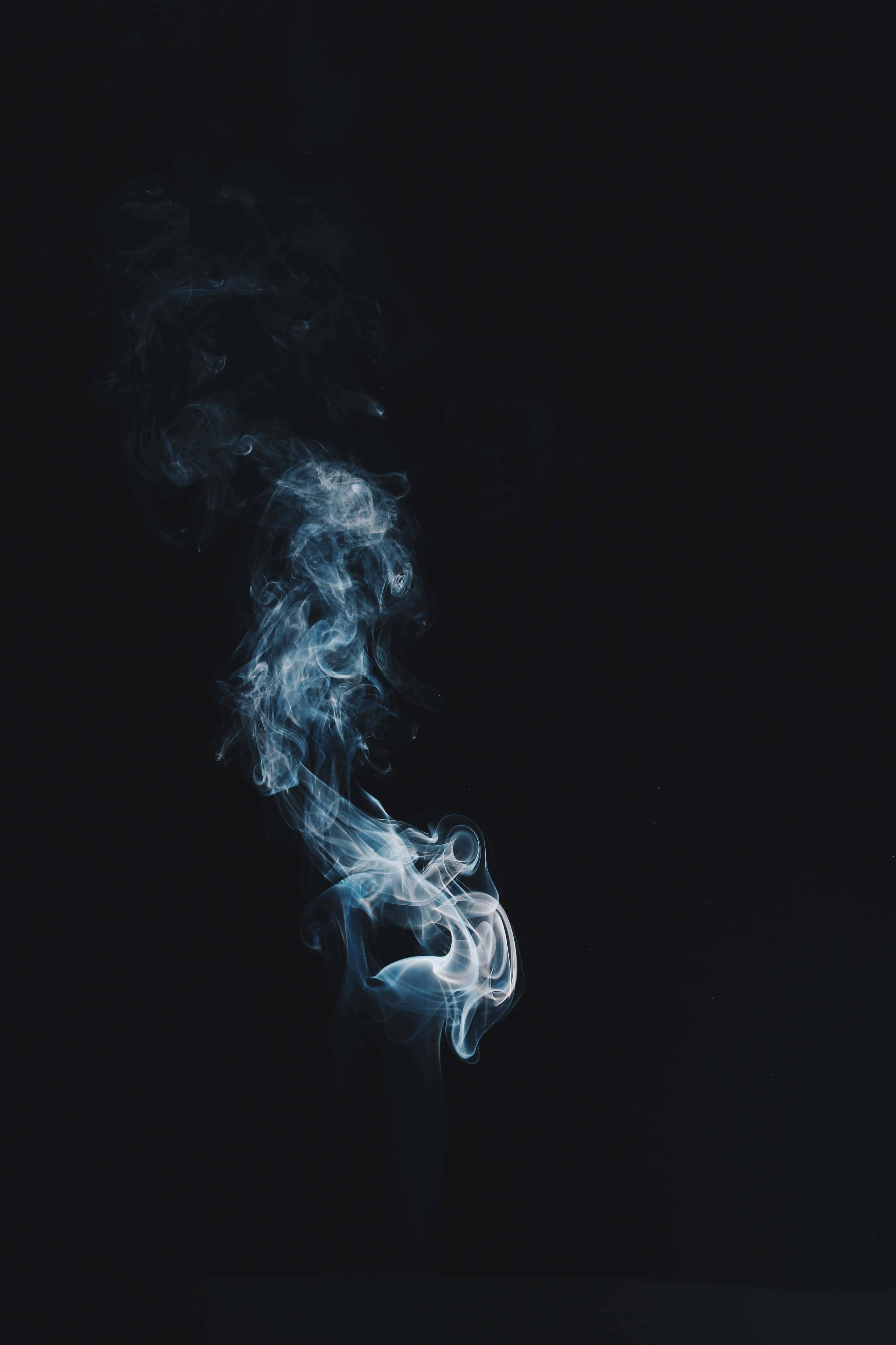 Smokey 桌布 壁紙 — 一縷纖細清涼的藍色煙霧，在深邃的黑色虛空中蜿蜒上升。