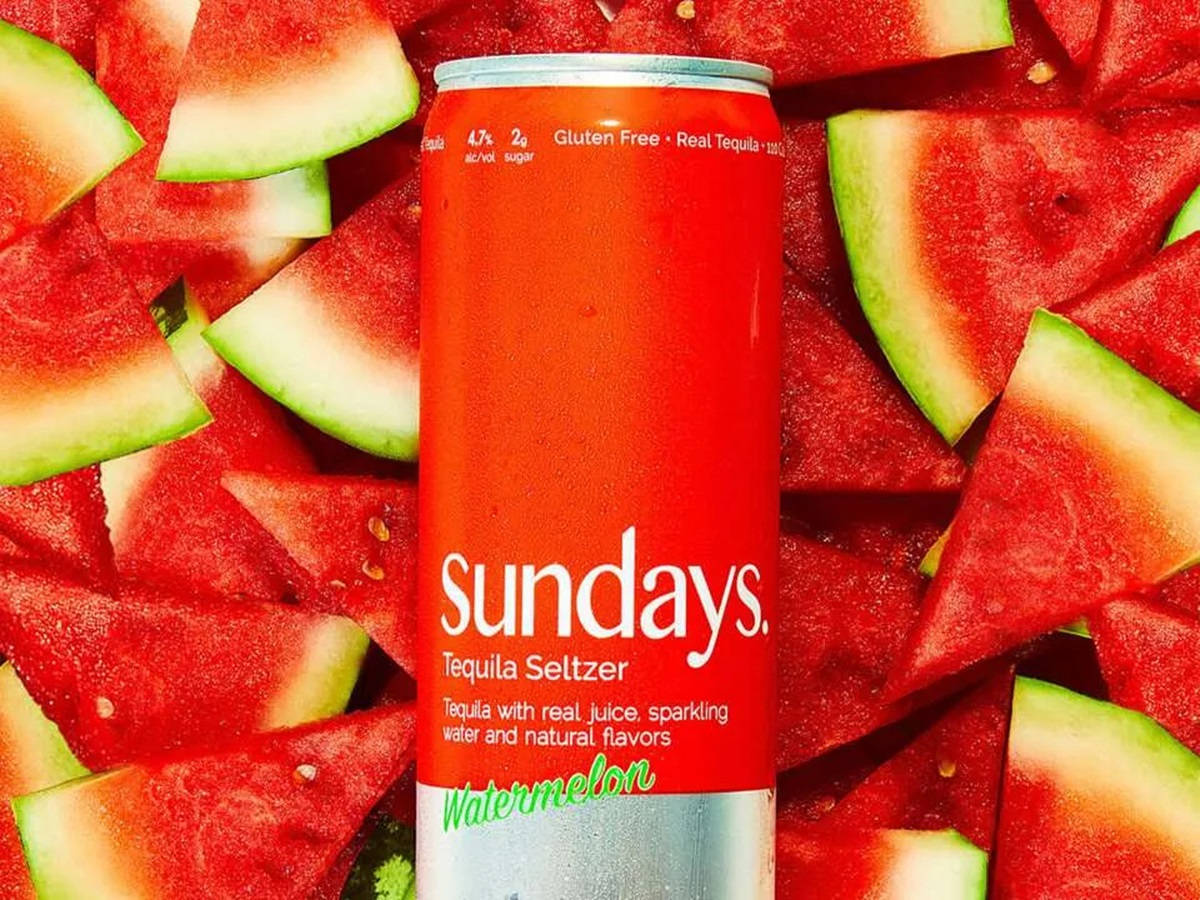 Watermelon 桌布 壁紙 — 一罐紅色的 Sundays Watermelon Tequila Seltzer 被鮮豔的西瓜片包圍。