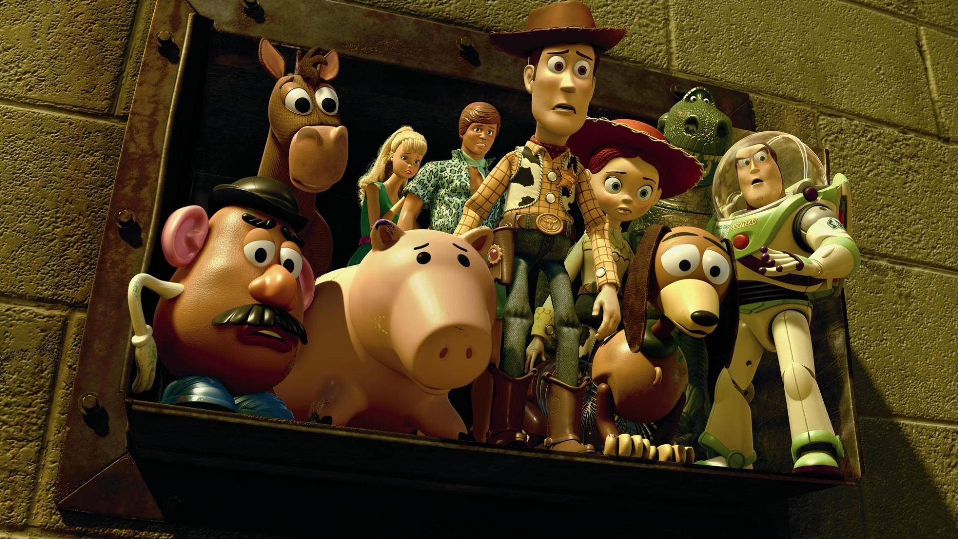 Toy Story 3 桌布 壁紙 — 一群《玩具總動員》角色從一個生鏽的金屬箱中探出頭來，背景是磚牆。