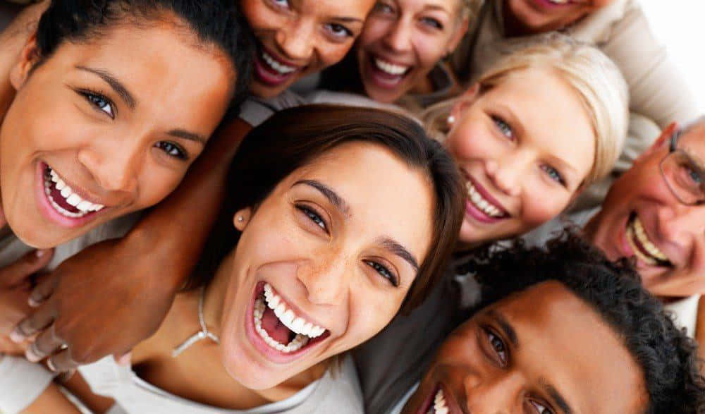 Smile 桌布 壁紙 — 一群不同背景的朋友在緊密的高角度鏡頭中一起歡笑。