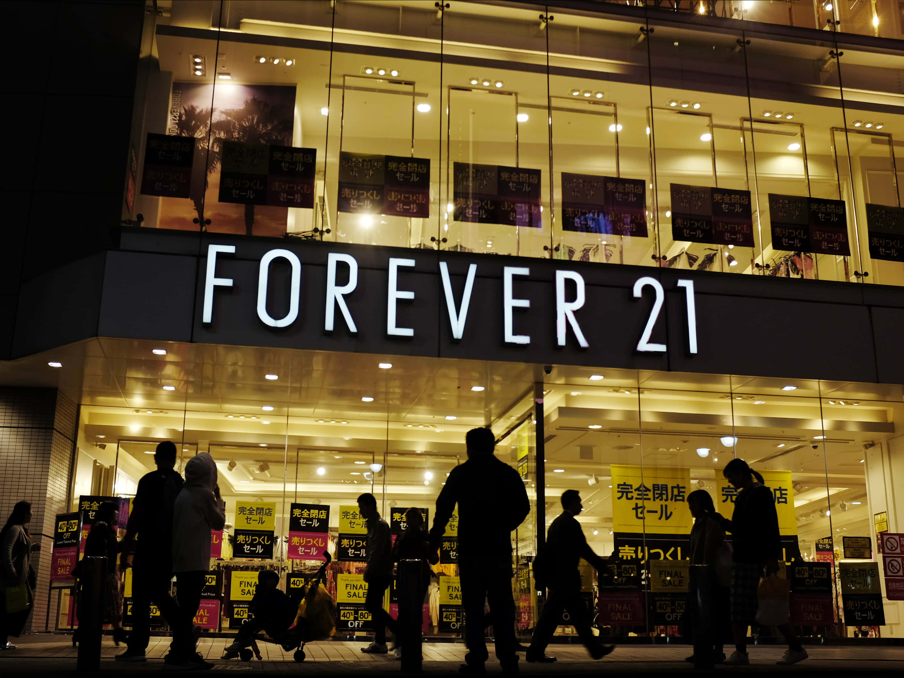 一群人在夜晚走過 Forever 21 商店 壁紙