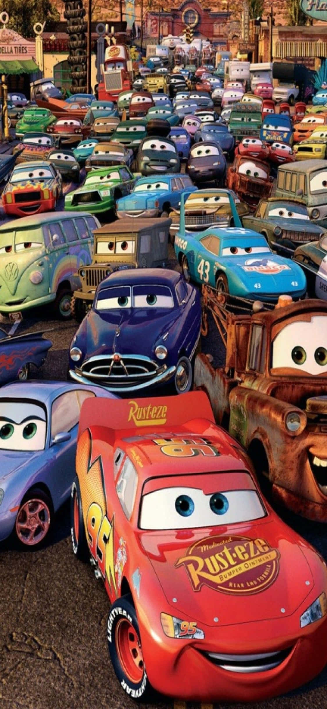 Lightning Mcqueen 桌布 壁紙 — 一群充滿活力的動畫汽車，表情豐富，擠在繁忙的城鎮街道場景中。