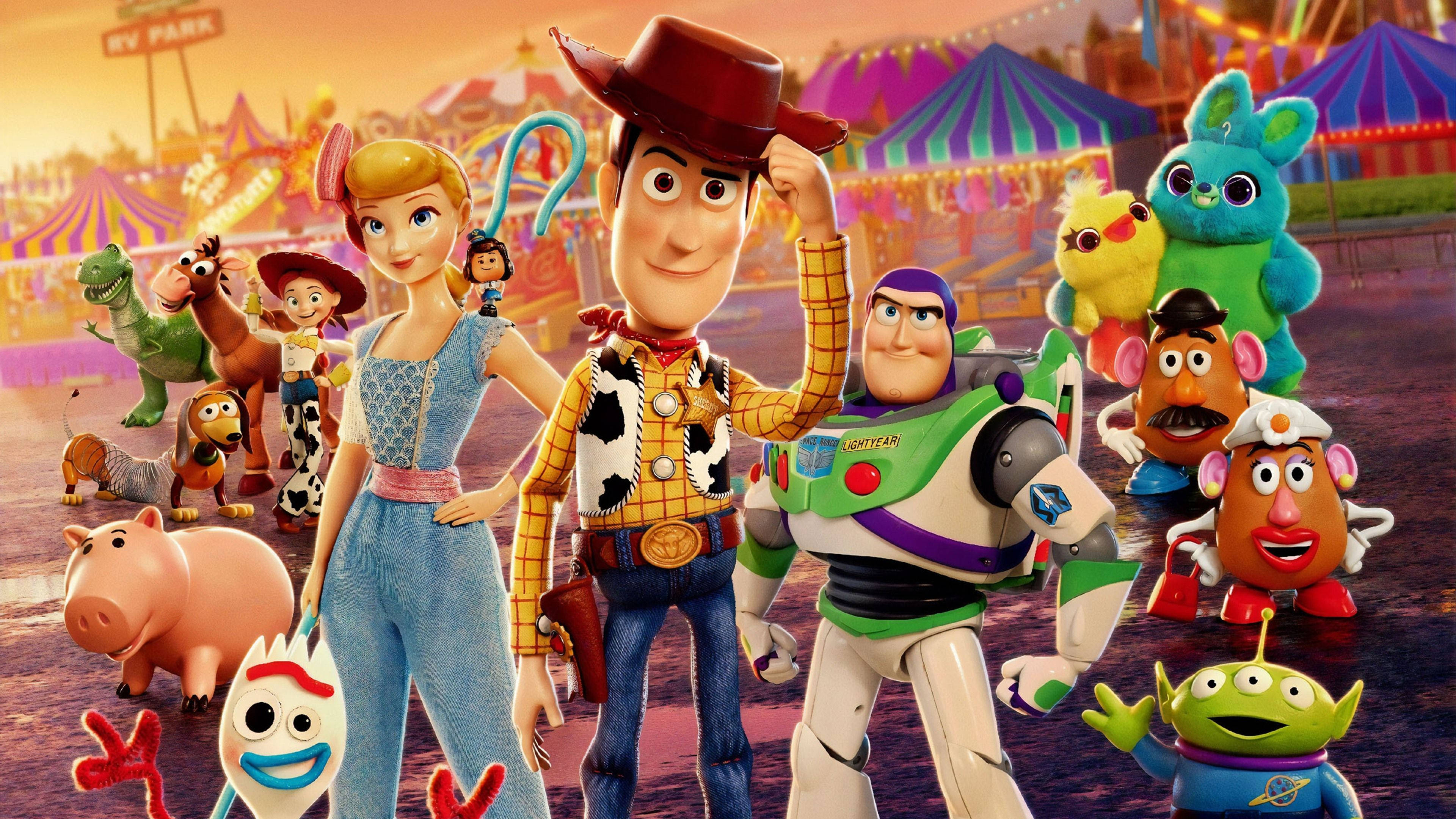 Toy Story 4 桌布 壁紙 — 一群充滿活力的玩具總動員角色在溫暖的日落天空下，於色彩繽紛的嘉年華場景中愉快地擺姿勢。