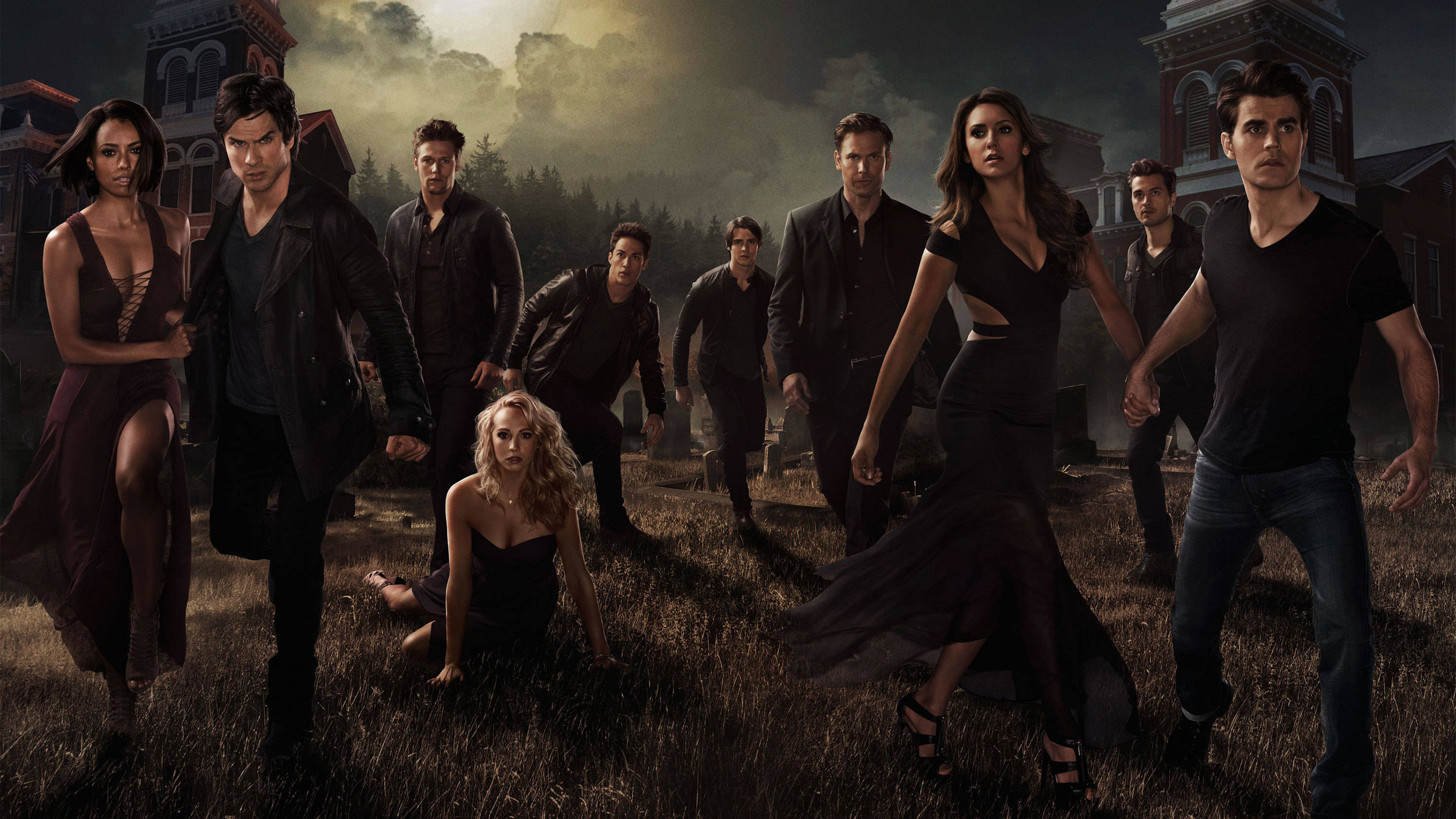 The Vampire Diaries 桌布 壁紙 — 一群吸血鬼和狼人在迷霧籠罩的墓地中，在暴風雨的天空下威嚇地站立。