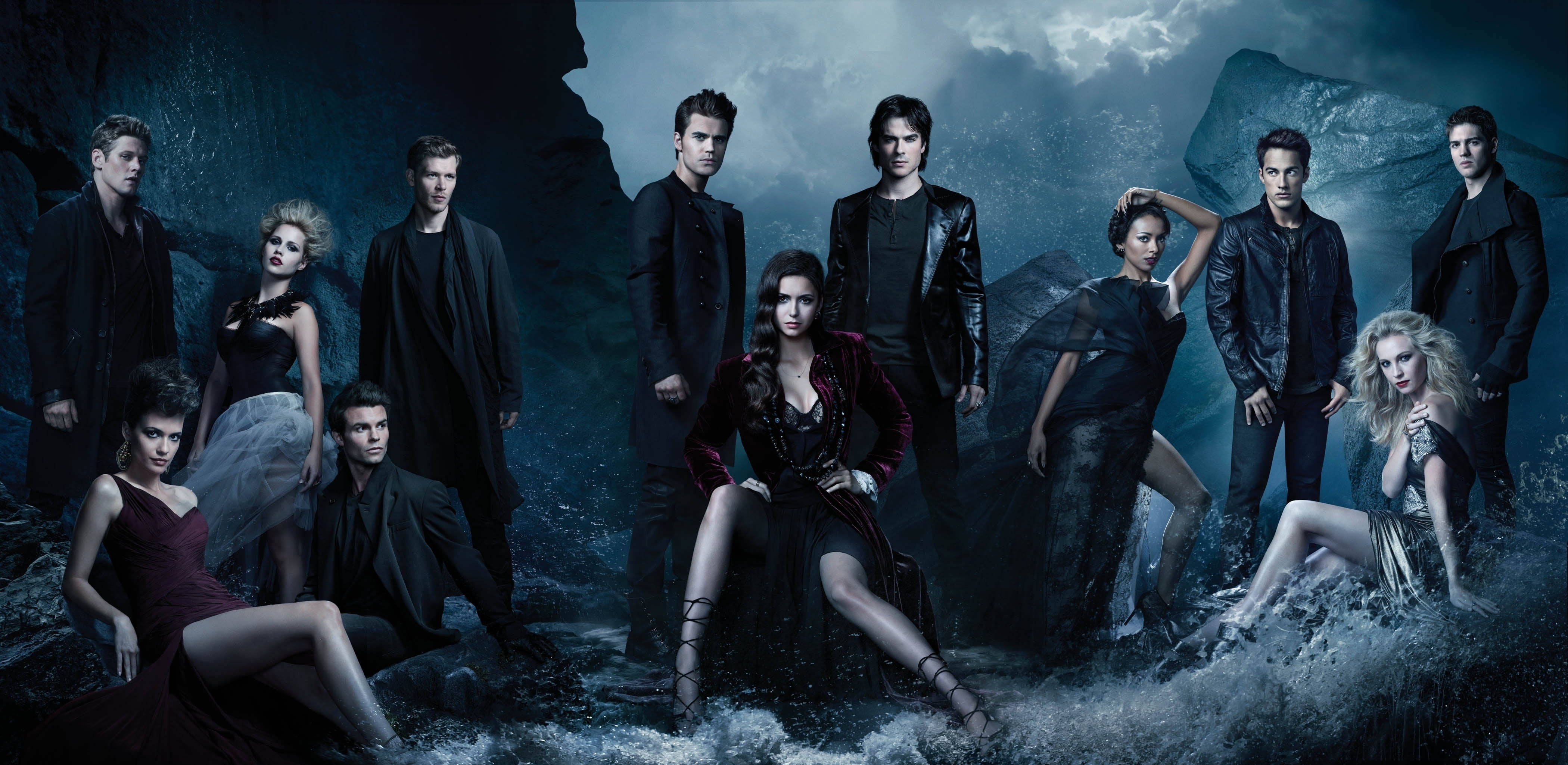 Vampire Diaries 桌布 壁紙 — 一群吸血鬼和狼人在黑暗天空下的暴風雨岩石海岸場景中戲劇性地擺姿勢。