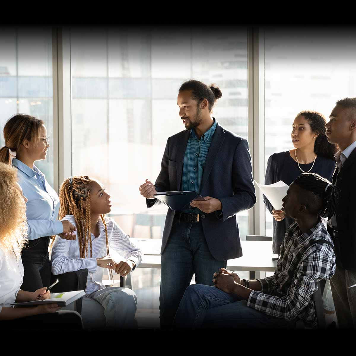 Leadership 桌布 壁紙 — 一群多元化的專業人士在現代辦公室中圍繞桌子進行專注的商務會議。