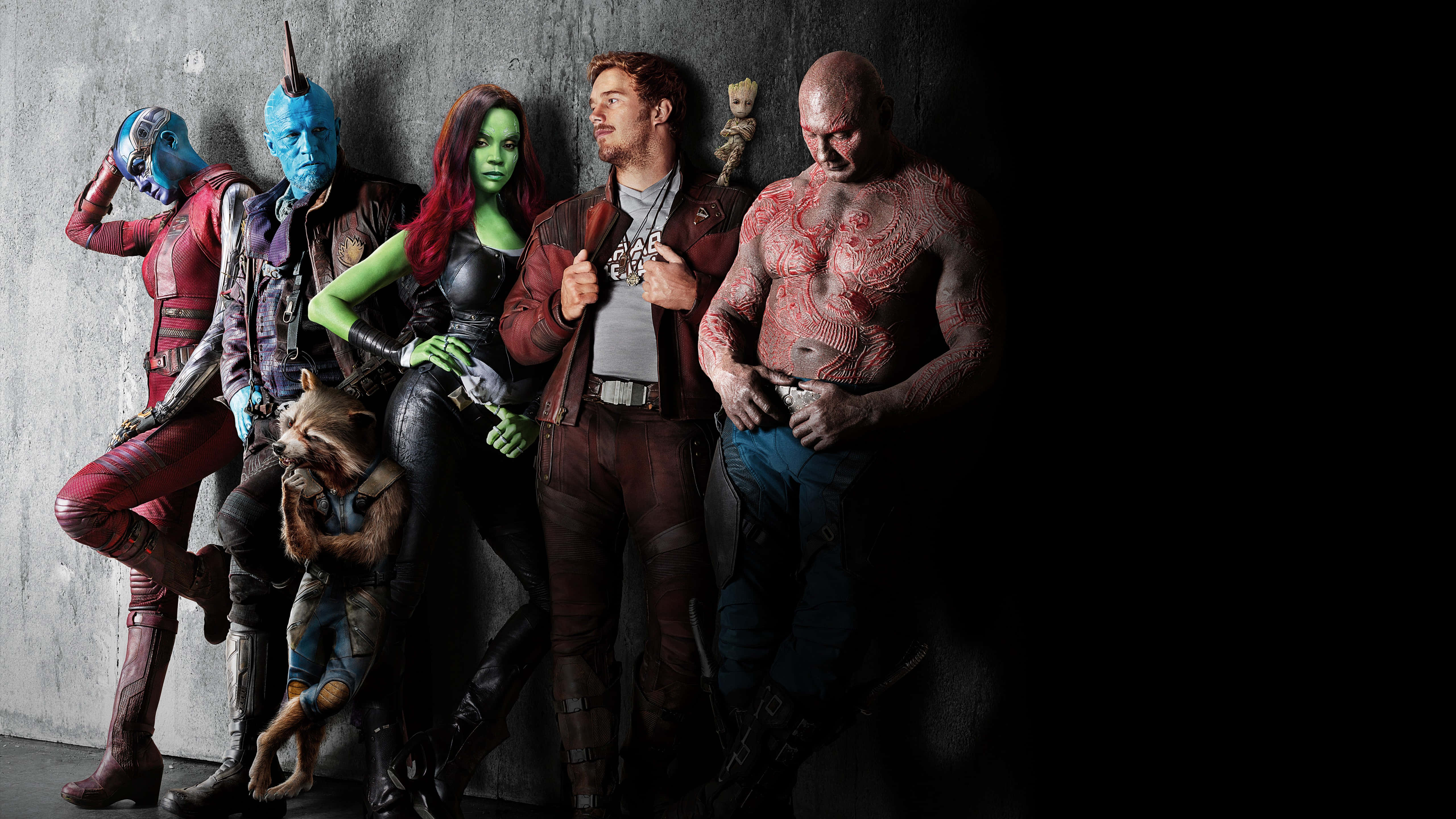 Guardians Of The Galaxy 2 桌布 壁紙 — 一群多樣化的外星人和人類角色穿著科幻服裝，在戲劇性燈光下於深色混凝土牆前擺姿勢。