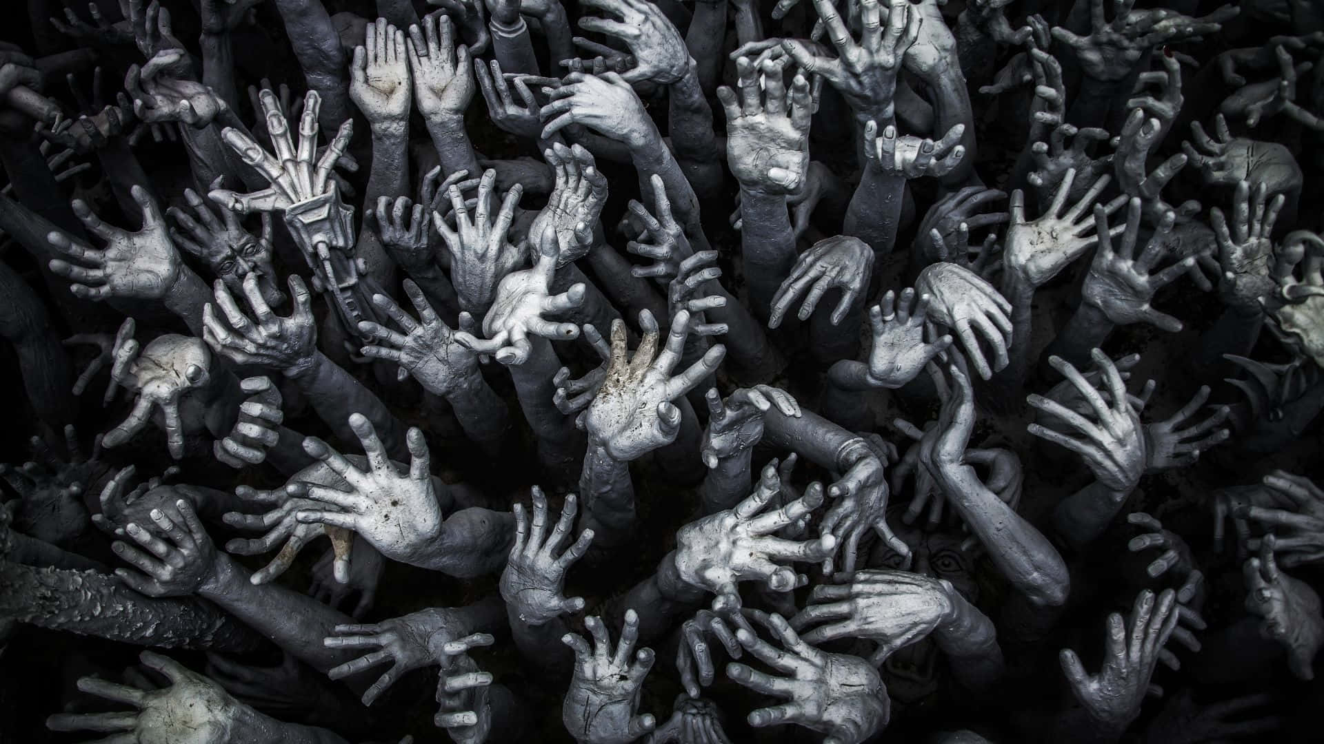 詭異的GIF 桌布 壁紙 — 一群密集的灰白色手從黑暗中向上伸出，構成一個令人難忘且富有紋理的畫面。