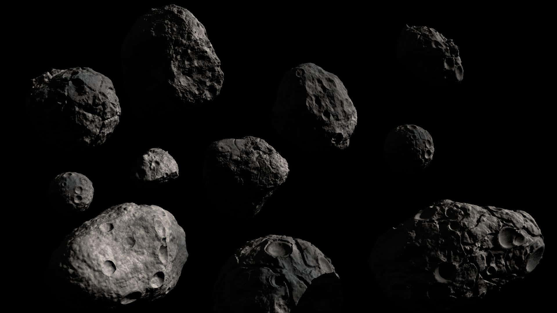Asteroid 桌布 壁紙 — 一群崎嶇的小行星在漆黑虛空中靜靜漂浮，它們佈滿隕石坑的表面捕捉著微弱的光芒。