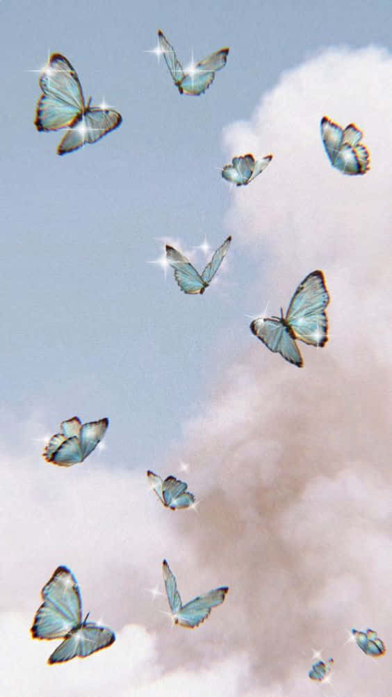 Cool Butterfly 桌布 壁紙 — 一群帶有閃爍翅膀的虹彩藍色蝴蝶，在柔和粉彩雲朵間優雅飄移，映襯著溫柔的天空。