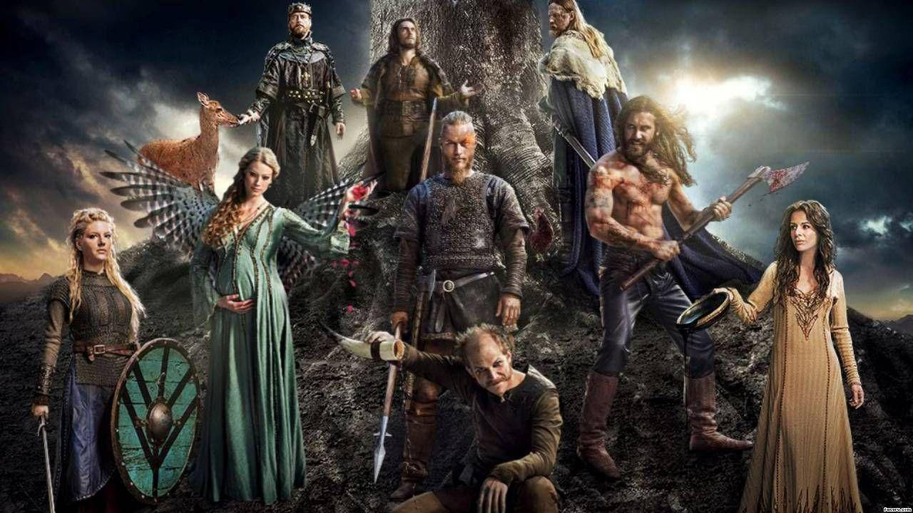 Vikings 桌布 壁紙 — 一群戲劇性的維京戰士和女性站在一棵巨大的樹周圍，天空風暴密佈，背後有發光的太陽。