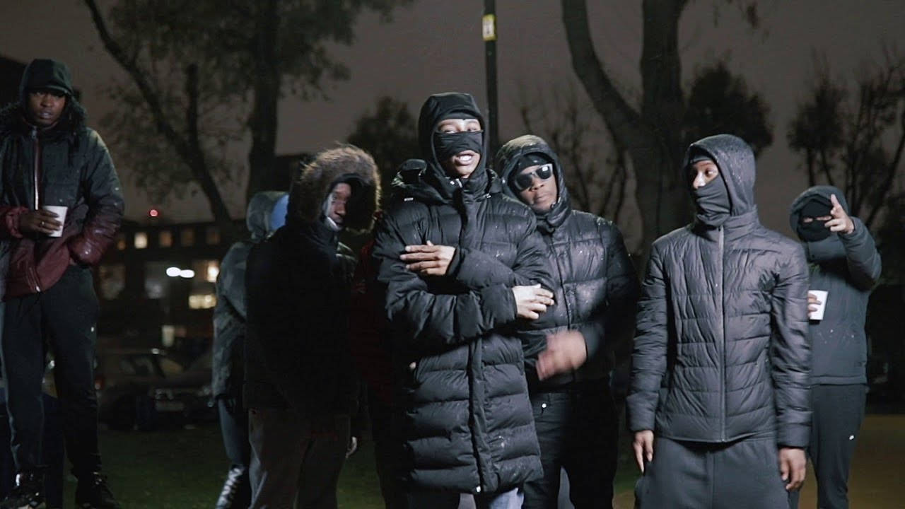 boys attitude 桌布 壁紙 — 一群戴著口罩、穿著羽絨外套的人夜晚站在燈光昏暗的城市公園中。