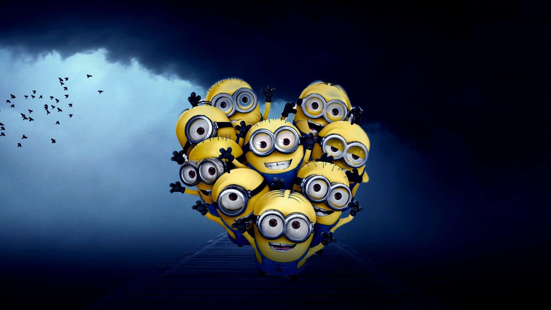 Minion 桌布 壁紙 — 一群戴著護目鏡和藍色工裝褲的黃色Minions以心形聚集，站在木製碼頭上，天空風暴來襲，鳥兒向左飛翔。