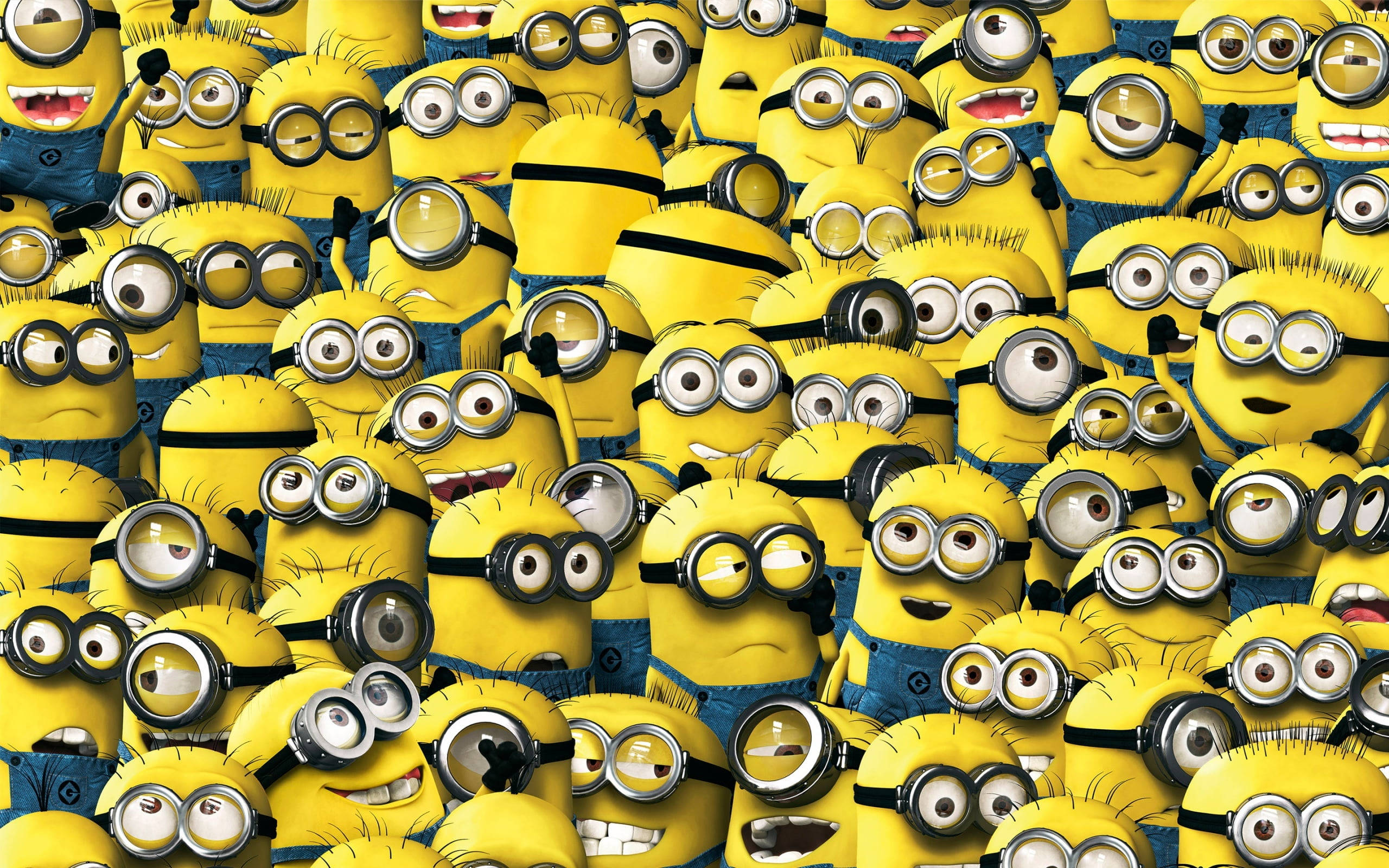 小黃人 桌布 壁紙 — 一群戴著護目鏡和藍色工裝褲的黃色Minions密集地擠滿了畫面，表情混亂。