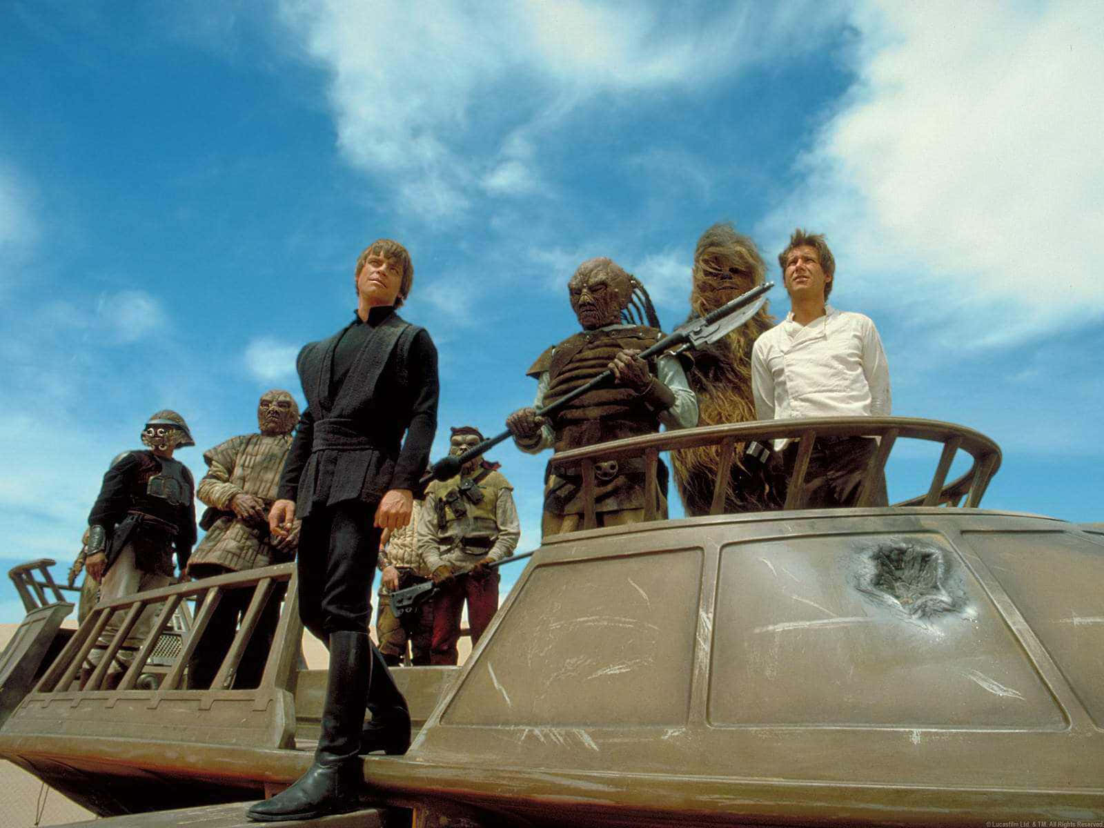 Return Of The Jedi 桌布 壁紙 — 一群星際大戰角色站在一艘受損的太空船上，天空湛藍，雲朵散佈。