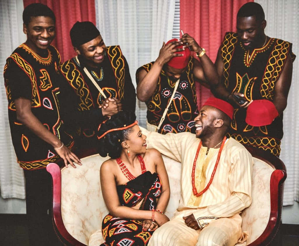 African Culture 桌布 壁紙 — 一群歡樂的人穿著鮮豔的傳統非洲服飾，在溫暖的室內環境中一起大笑。