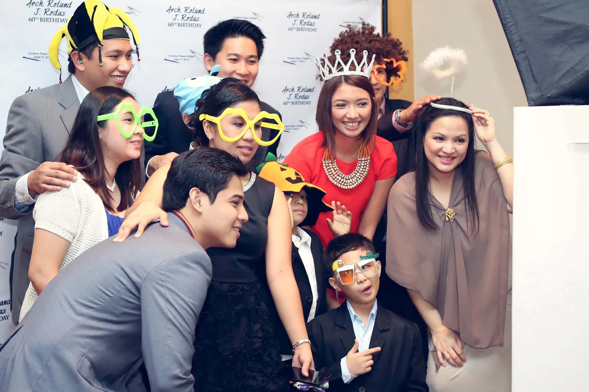 Photobooth 桌布 壁紙 — 一群歡樂的成人和兒童戴著有趣的萬聖節道具，在生日派對上一起擺姿勢。