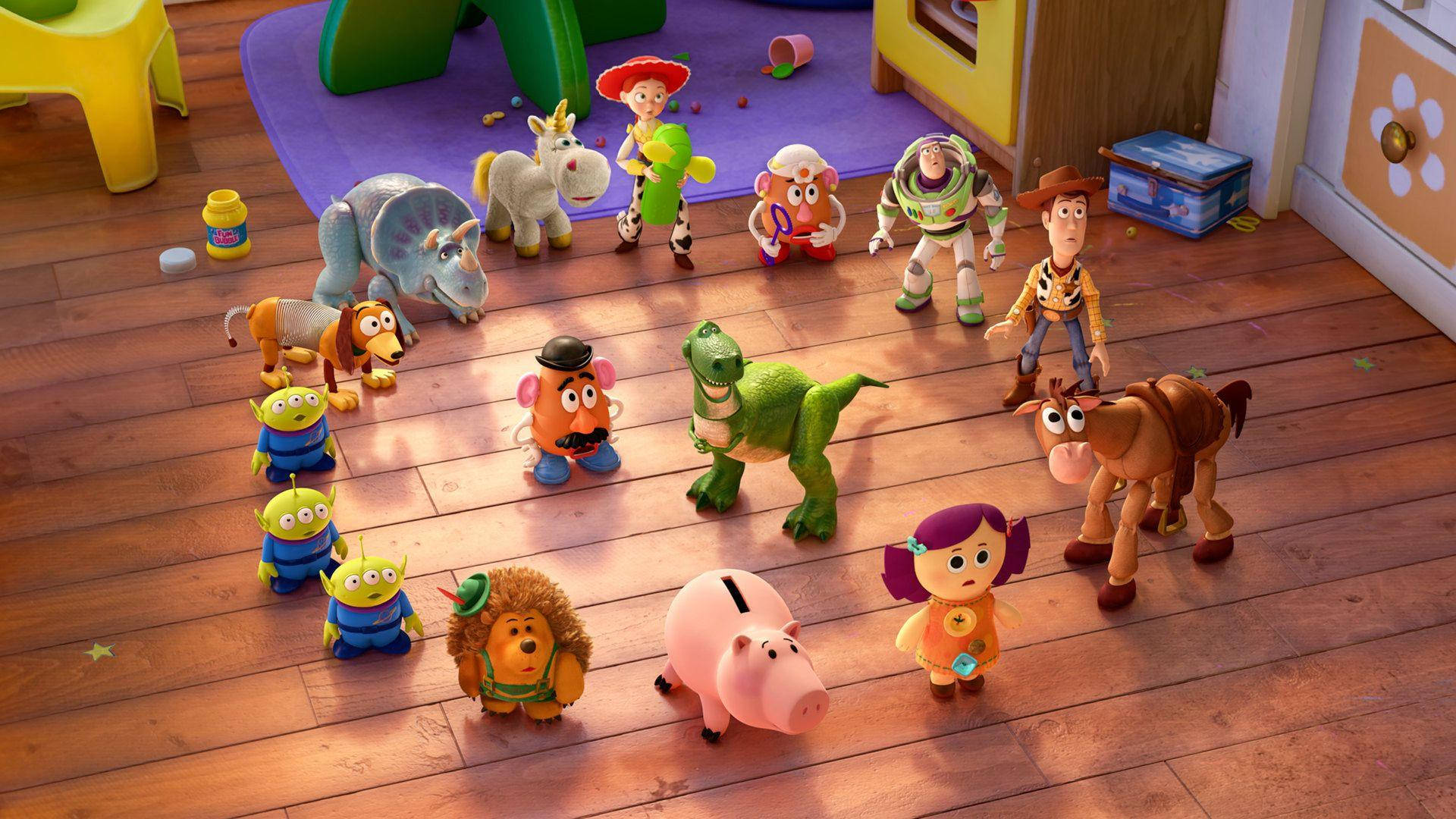 Toy Story 3 桌布 壁紙 — 一群活潑的《玩具總動員》角色站在色彩繽紛的兒童遊戲室的木地板上。