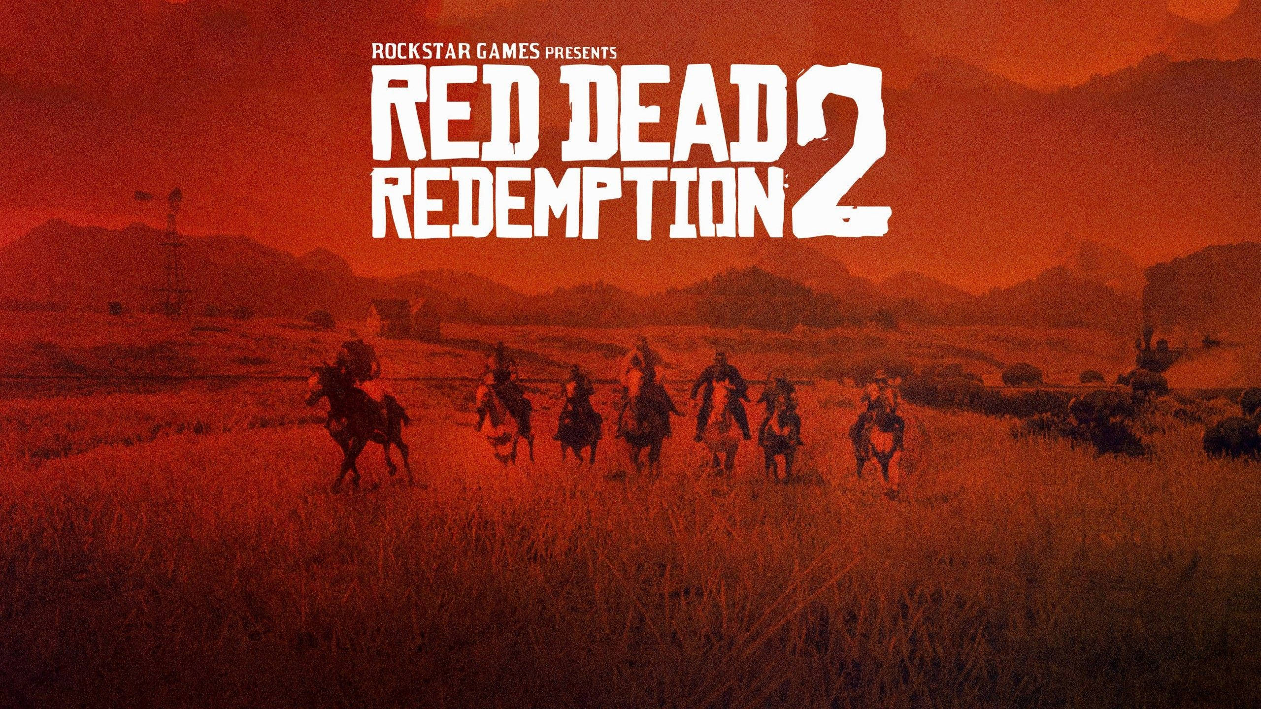 Red Dead Redemption 2 Desktop 桌布 壁紙 — 一群牛仔騎馬穿過廣闊的草地平原，天空呈現火紅的日落景色，遊戲標題清晰顯示。