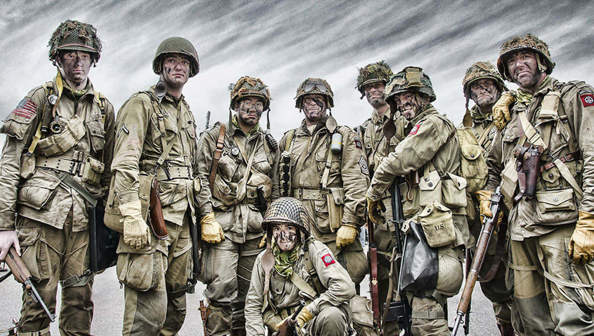 Marines 桌布 壁紙 — 一群疲憊的二戰士兵身穿全套戰鬥裝備，在暴風雨般的灰色天空下莊嚴地擺姿勢。