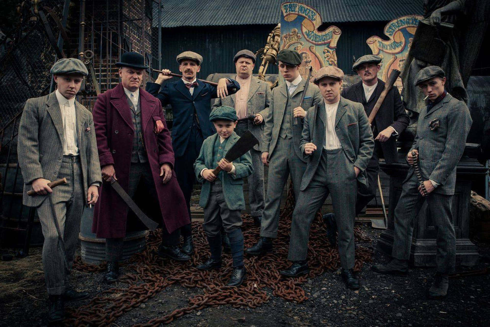 男人和一個男孩穿著1920年代黑幫服裝，在工業環境中手持武器。 — Peaky Blinders 壁紙