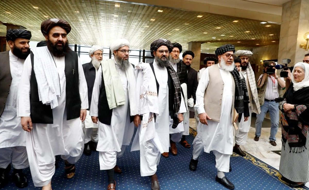 Taliban 桌布 壁紙 — 一群穿著傳統服飾的阿富汗男子走過宏偉的飯店大廳，攝影師們捕捉了這一刻。