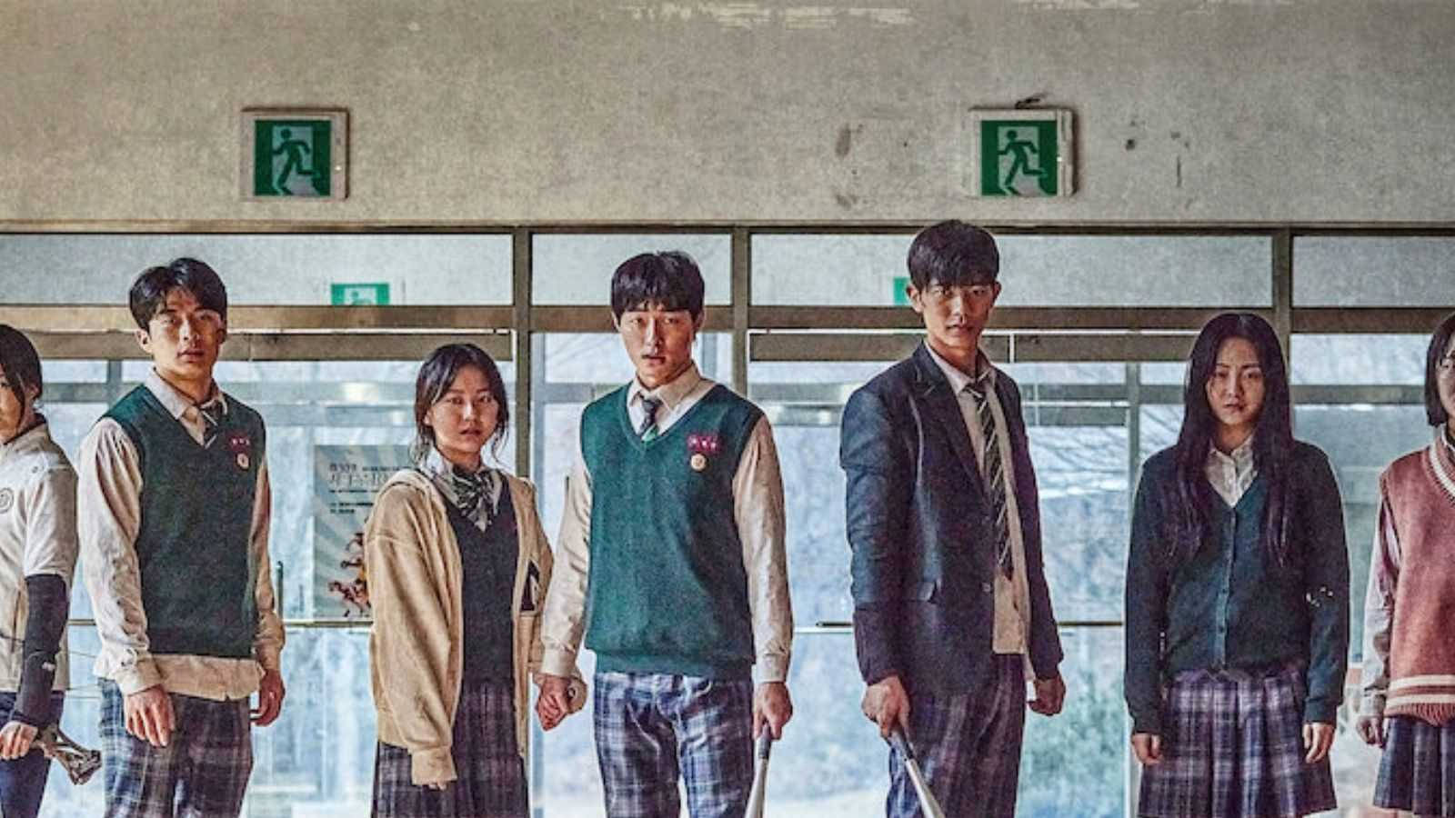 kdrama 桌布 壁紙 — 一群穿著制服的高中生在光線昏暗的學校走廊上莊嚴地站著，上方有緊急出口標誌。
