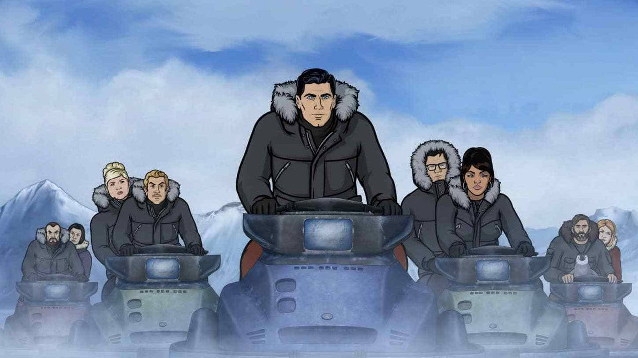 archer 桌布 壁紙 — 一群穿著厚重冬季裝備的人們在陰天之下，騎著雪地摩托車穿越白雪覆蓋的山地景觀。