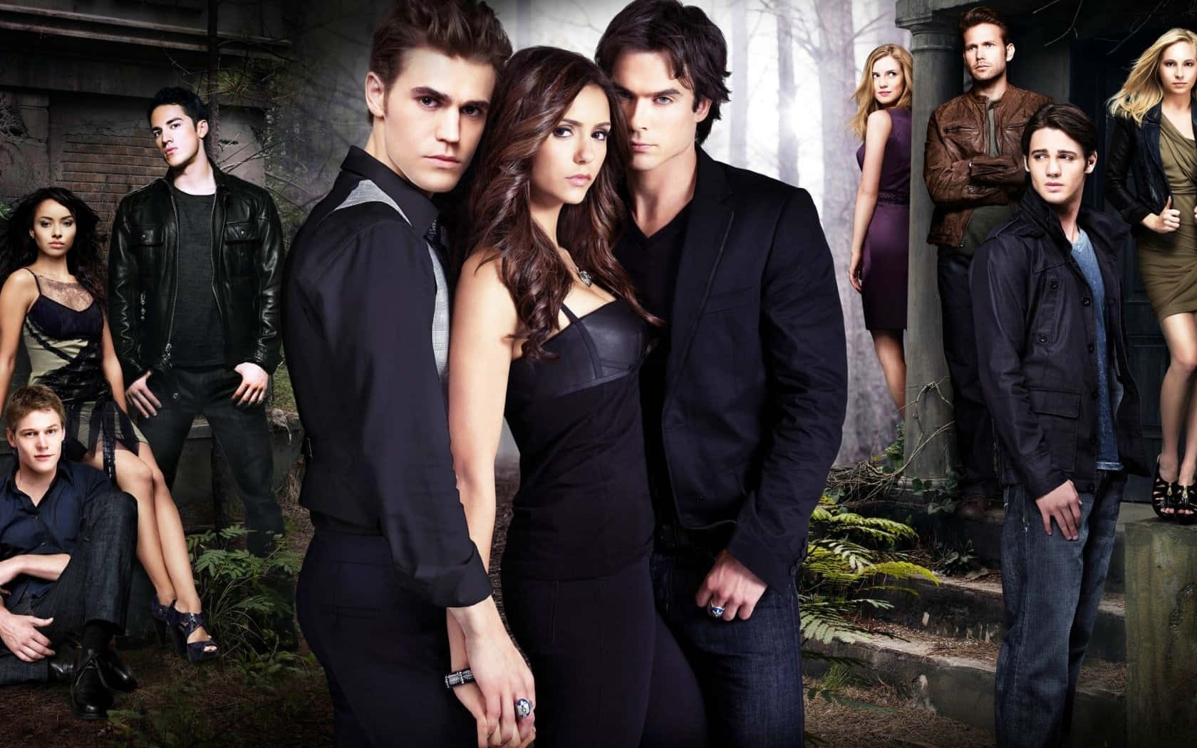 Vampire Diaries Desktop 桌布 壁紙 — 一群穿著深色衣服的年輕成年人在霧氣瀰漫的森林中，與石頭廢墟和蕨類植物一起戲劇性地擺姿勢。