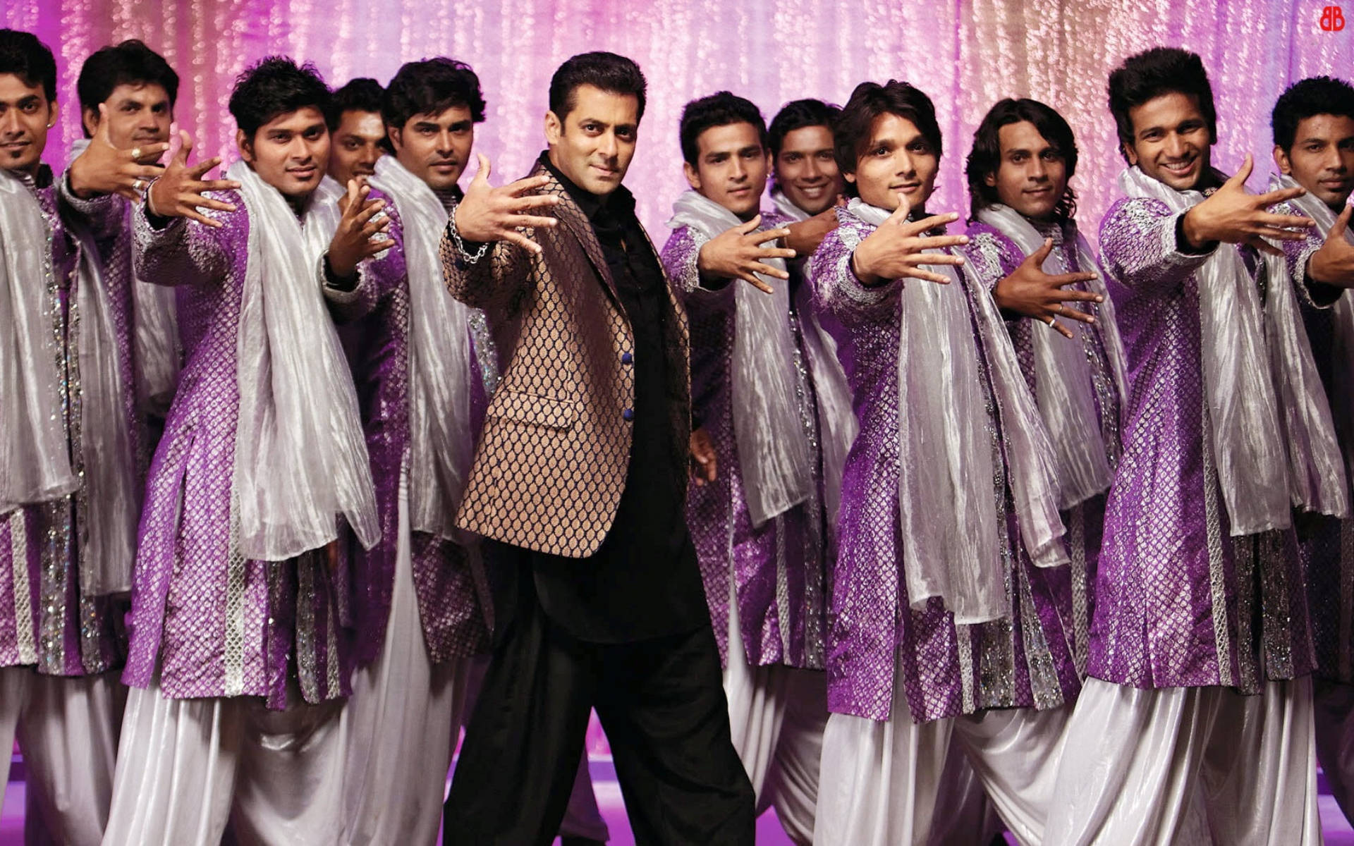 Salman Khan 桌布 壁紙 — 一群穿著紫色和白色傳統服裝的男子在閃爍的粉紅色背景下自信地擺姿勢。