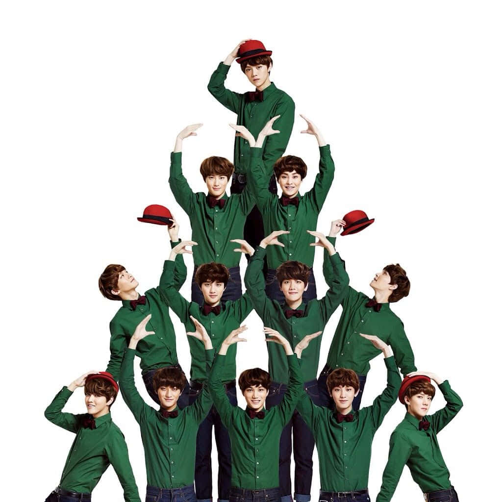 EXO 桌布 壁紙 — 一群穿著綠色襯衫和紅色帽子的年輕男子以金字塔形狀排列，在純白背景前做出同步的手勢。