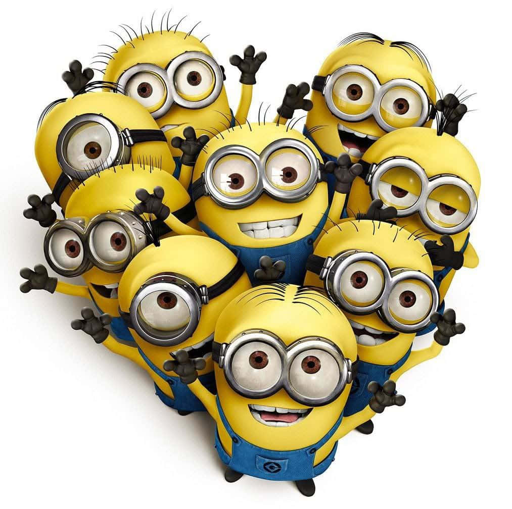 小小兵 桌布 壁紙 — 一群穿著藍色工裝褲的黃色Minions，在白色背景前開心地揮手，露出燦爛的笑容。