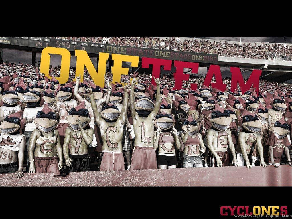 運動 桌布 壁紙 — 一群穿著青蛙吉祥物服裝的球迷在巨大的「ONE TEAM」標誌下舉起手臂歡呼。