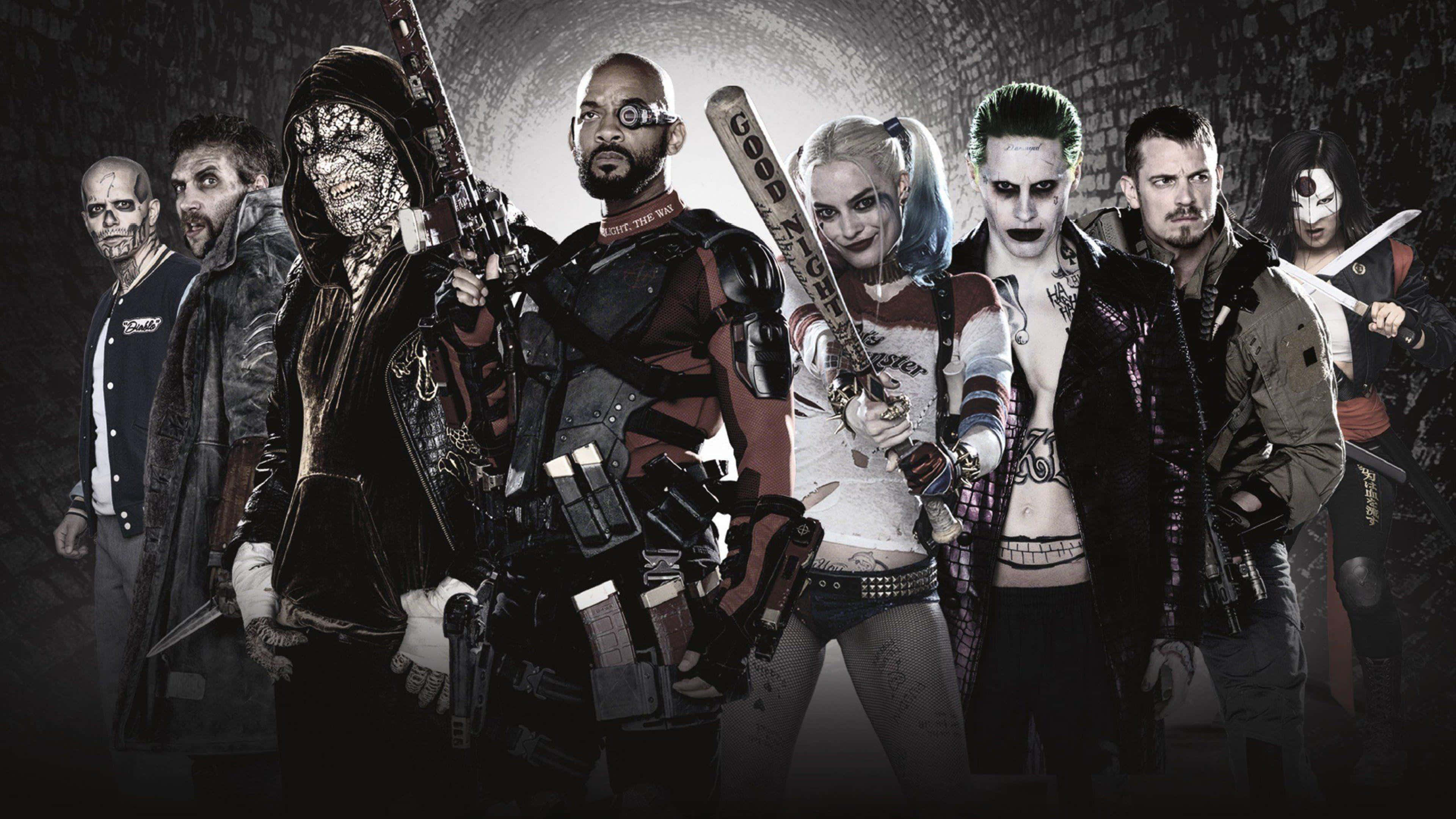 The Suicide Squad 桌布 壁紙 — 一群粗獷的DC反派，包括哈莉·奎茵和小丑，在黑暗的磚隧道中威嚇地站立。