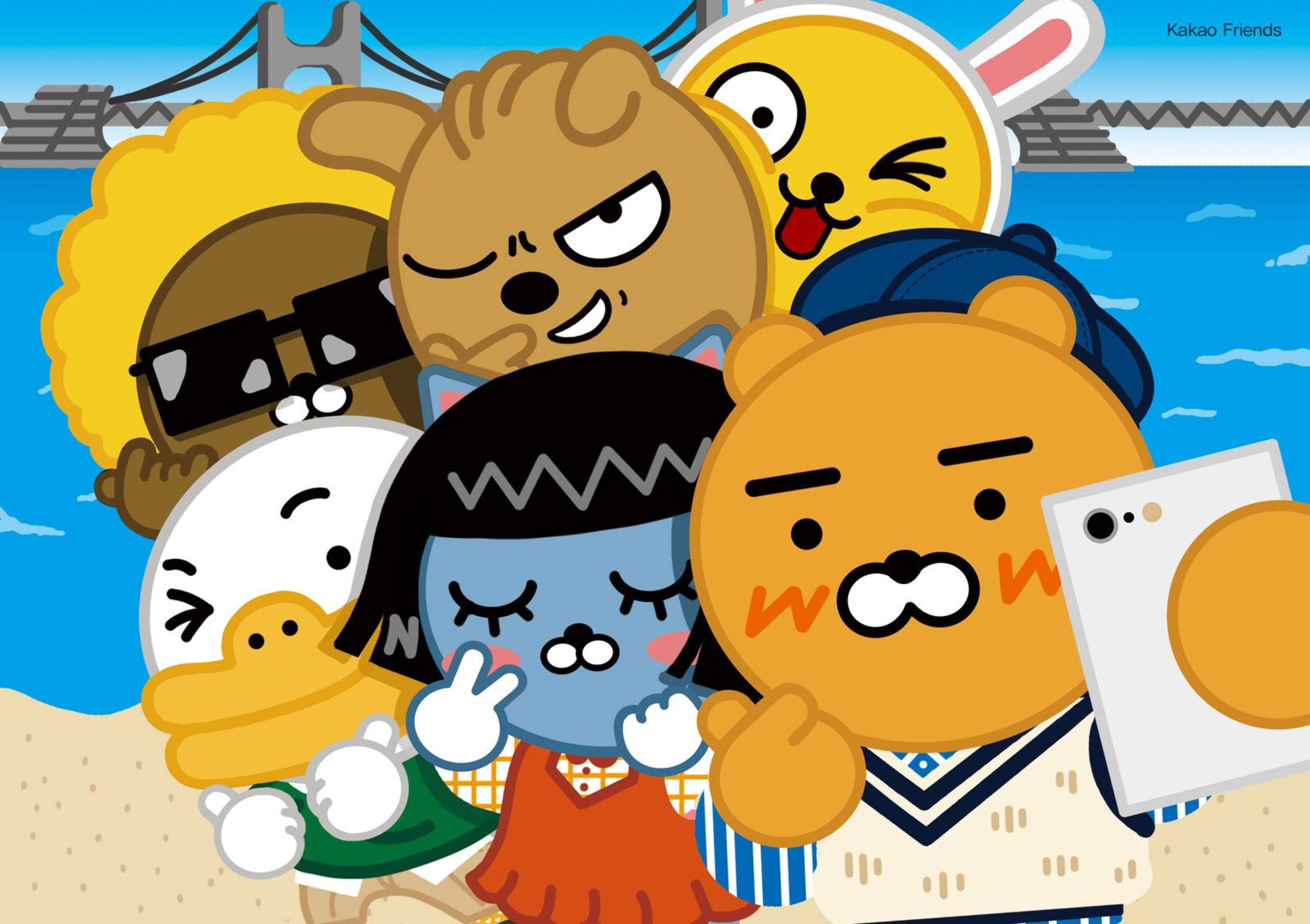 Kakao 桌布 壁紙 — 一群色彩繽紛的 Kakao Friends 卡通角色在陽光明媚的海灘上愉快地擺姿勢，背景有一座橋。