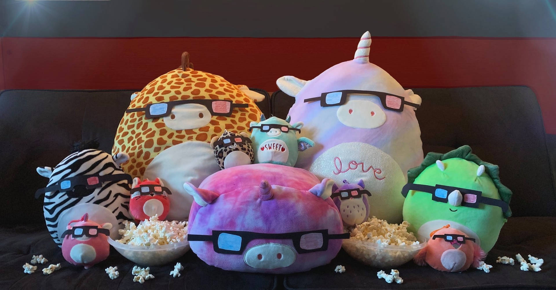 毛絨玩具戴著3D眼鏡，一邊吃爆米花一邊看電影。 — Squishmallows 壁紙