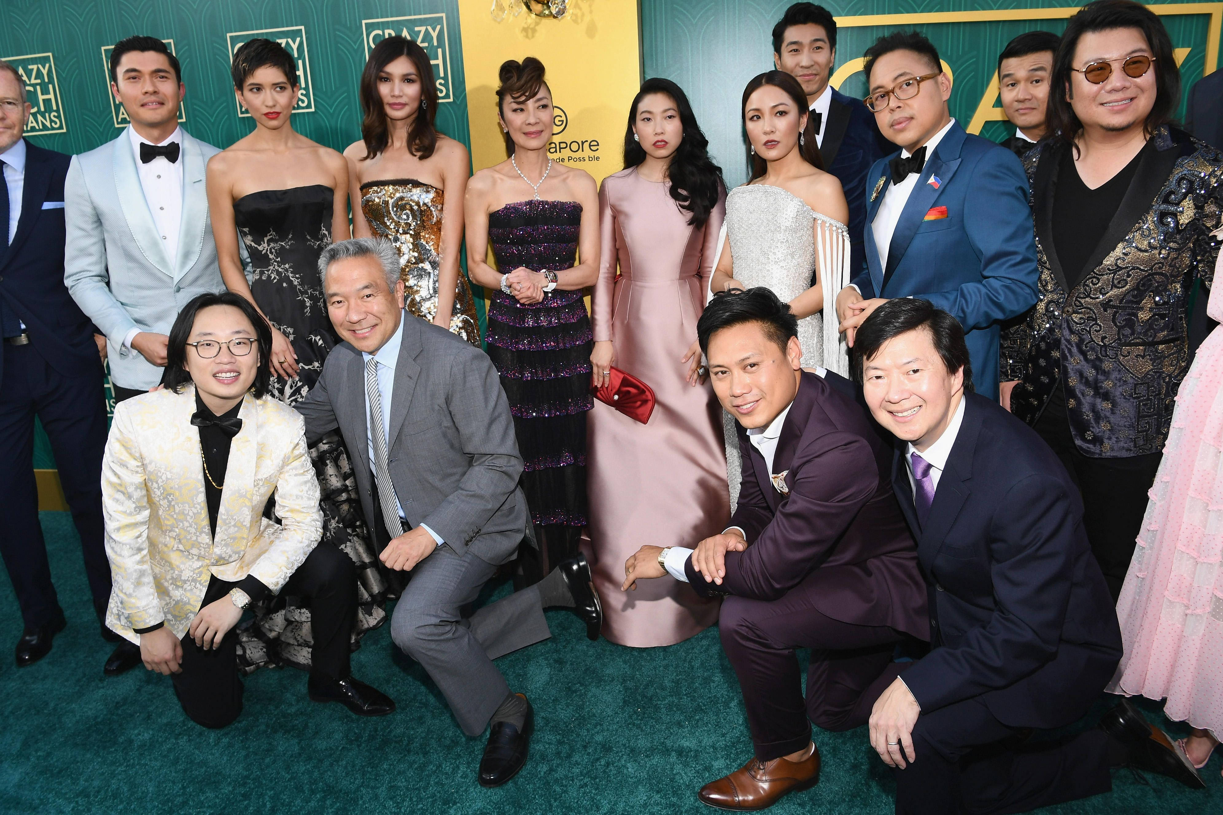 Awkwafina 桌布 壁紙 — 一群衣著優雅的亞洲名人，在華麗的頒獎典禮綠地毯上一起擺姿勢。