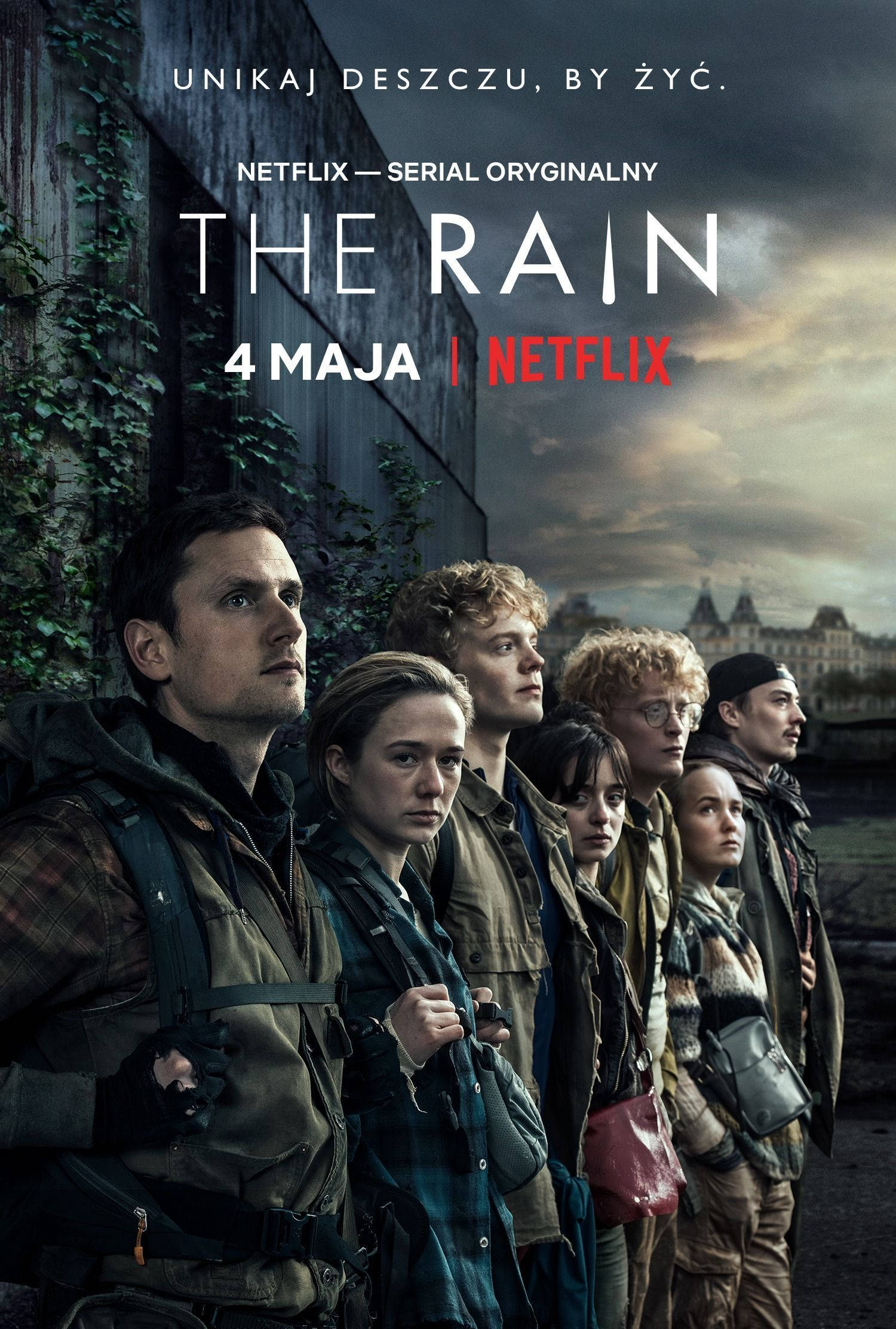 Netflix 桌布 壁紙 — 一群身穿堅固裝備的年輕倖存者，在暴風雨的天空下，莊嚴地站在破敗的城市背景前。