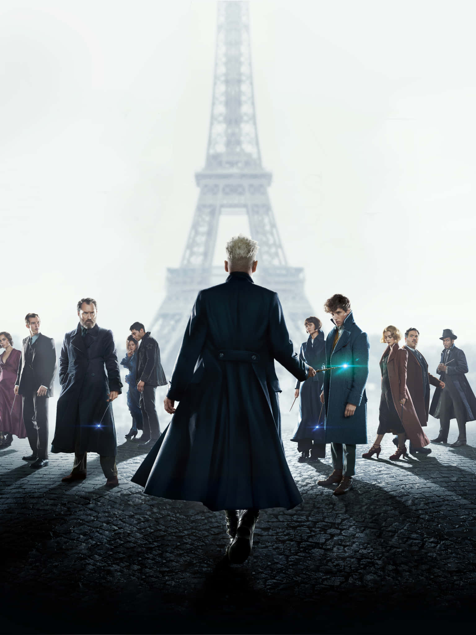 Fantastic Beasts 桌布 壁紙 — 一群身穿深色外套的巫師站在鵝卵石街道上，艾菲爾鐵塔在迷霧背景中若隱若現。