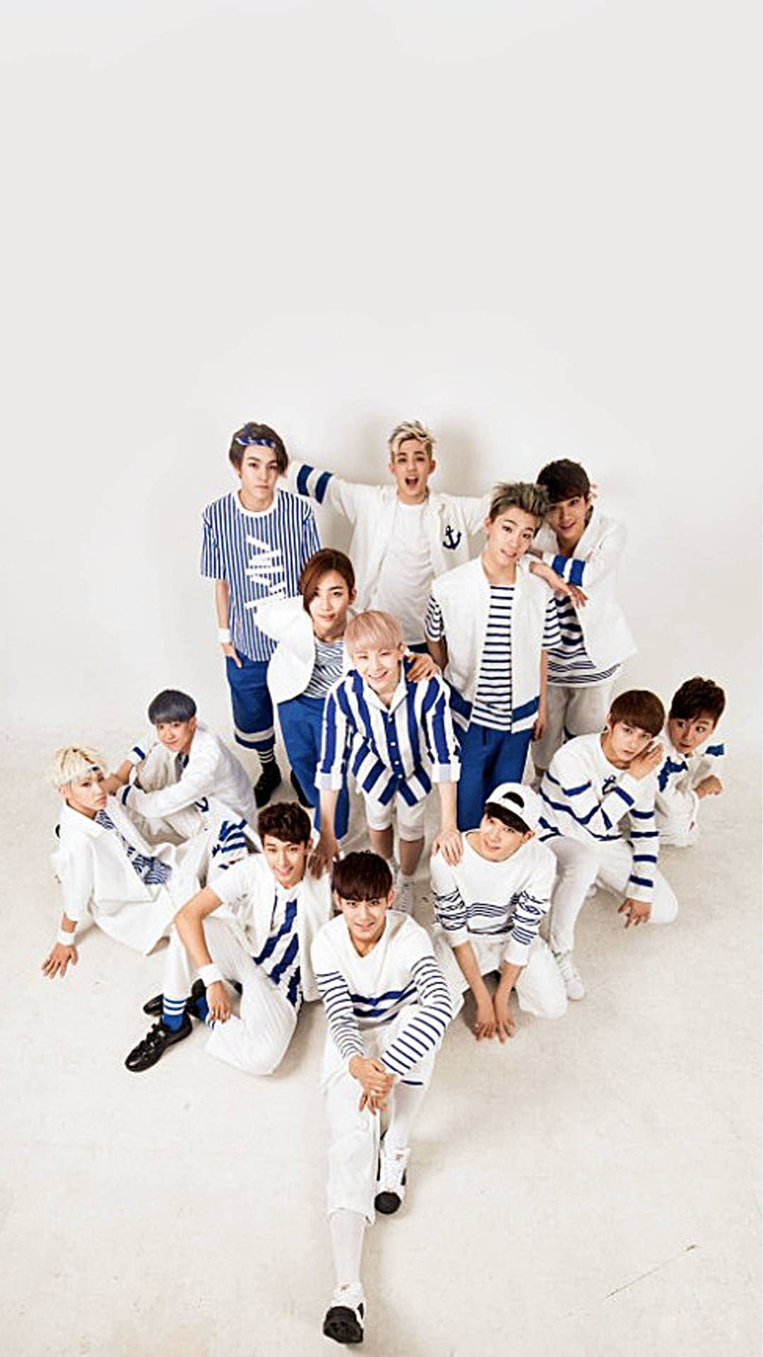 Ikon 桌布 壁紙 — 一群身穿白藍條紋水手服的年輕男子在純白工作室背景前充滿活力地擺姿勢。
