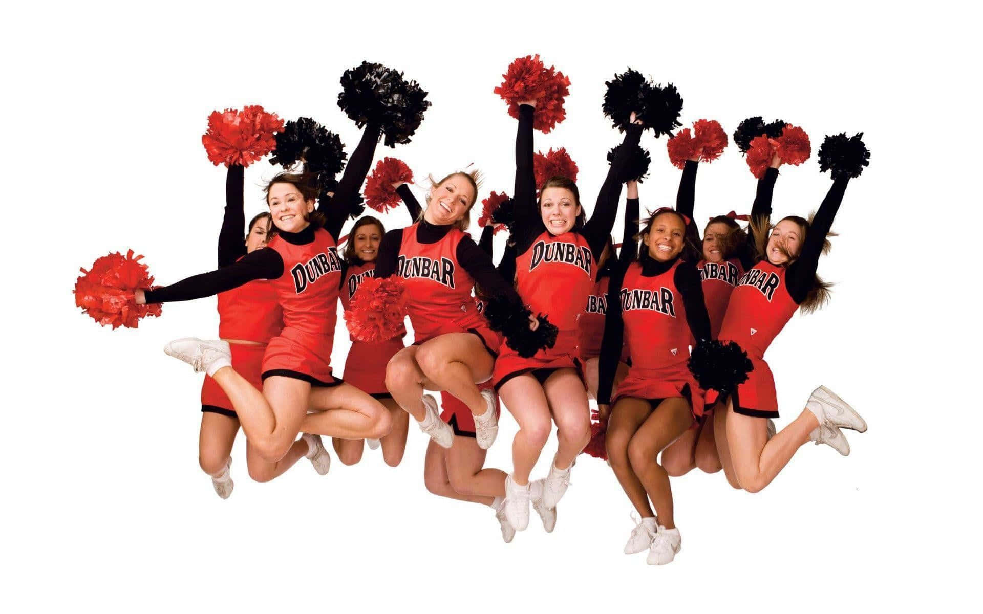 Cheer 桌布 壁紙 — 一群身穿紅色制服、手持黑色絨球的啦啦隊員在純白背景前歡樂跳躍。