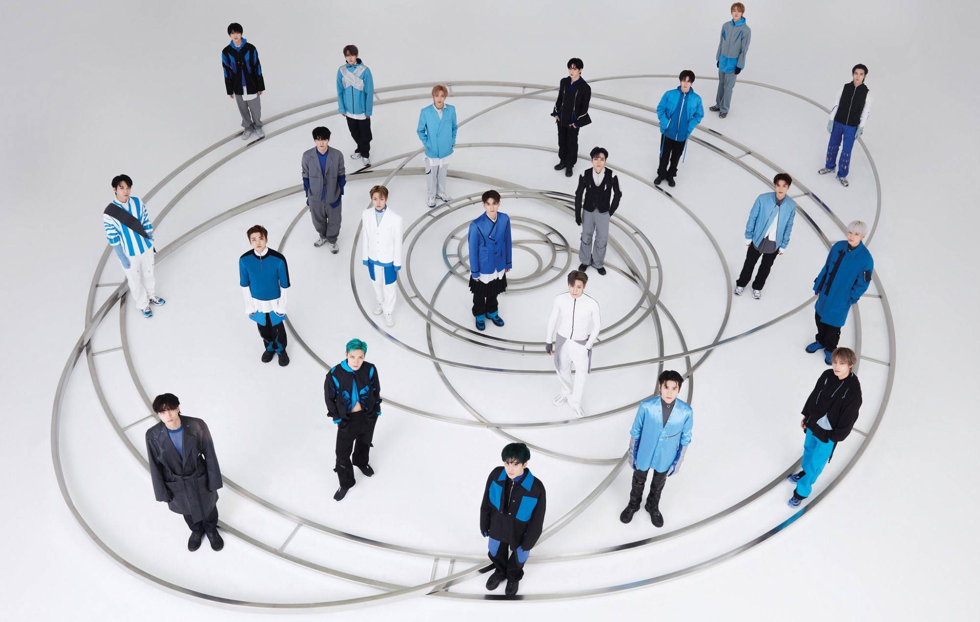 Nct 桌布 壁紙 — 一群身穿藍白服裝的年輕男子站在同心金屬環上，背景是純白的攝影棚。