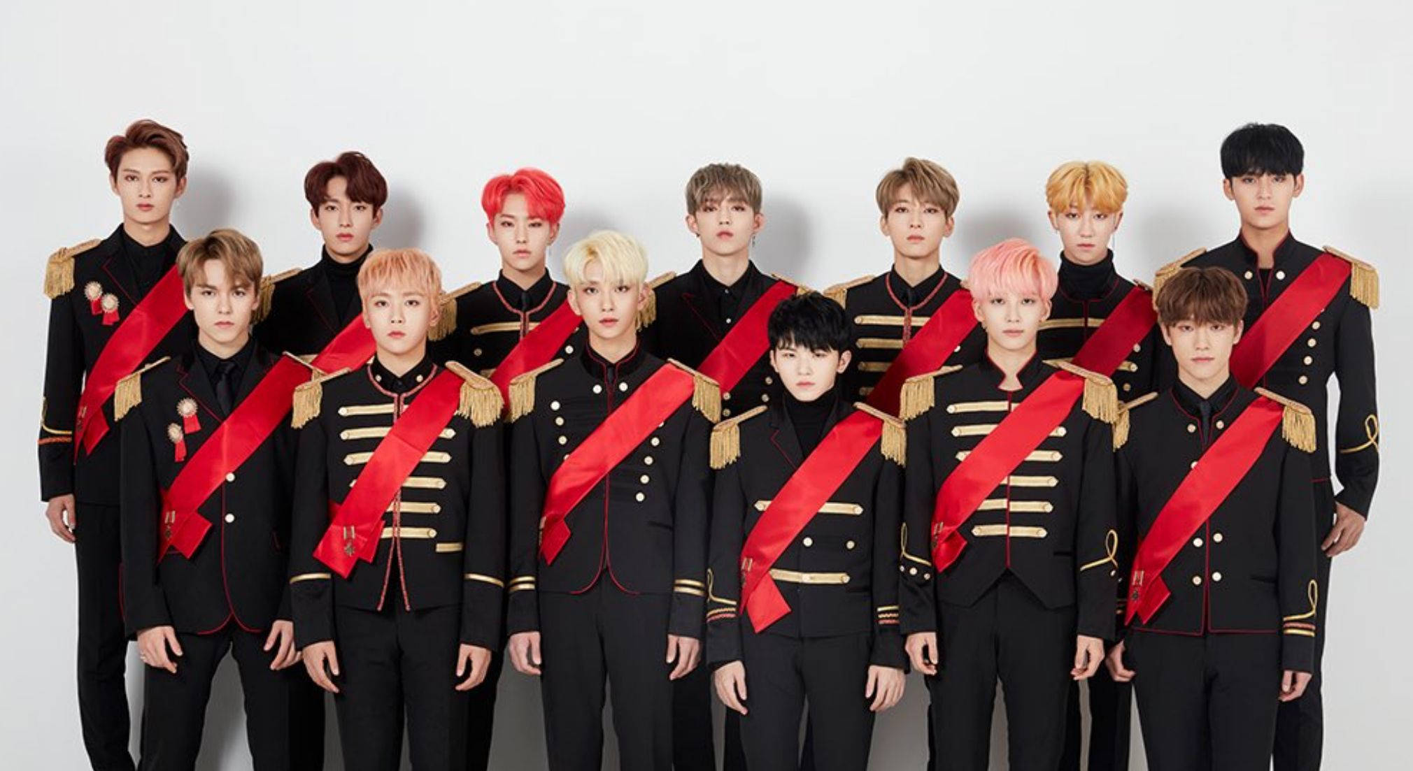 Wonwoo 桌布 壁紙 — 一群身穿黑色軍裝風格制服、配紅色肩帶和金色飾邊的年輕男性，在純白背景前擺姿勢。