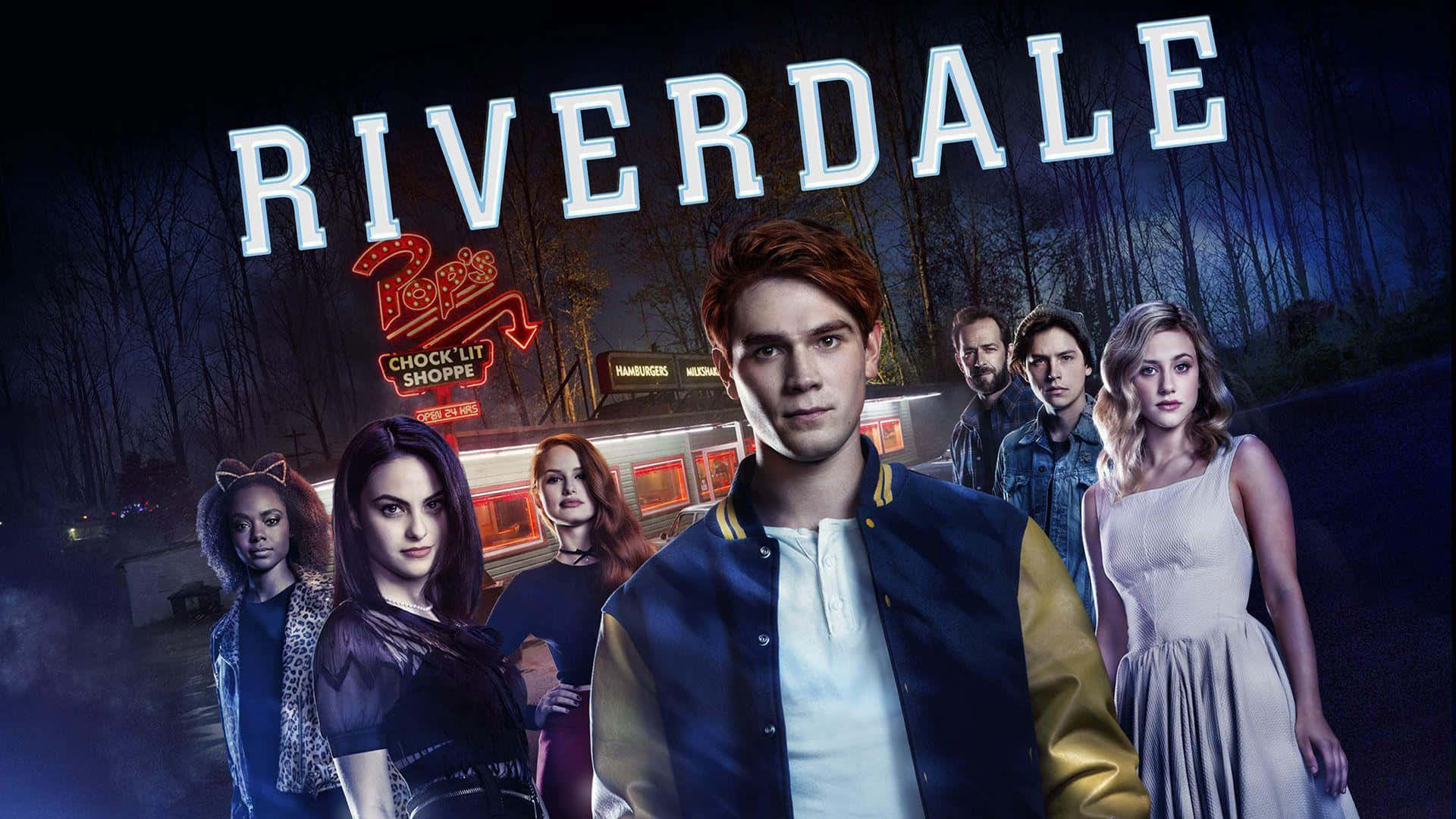 河谷鎮 桌布 壁紙 — 一群青少年夜晚站在發光的 Riverdale 標誌下，背景是霓虹燈點亮的餐廳。