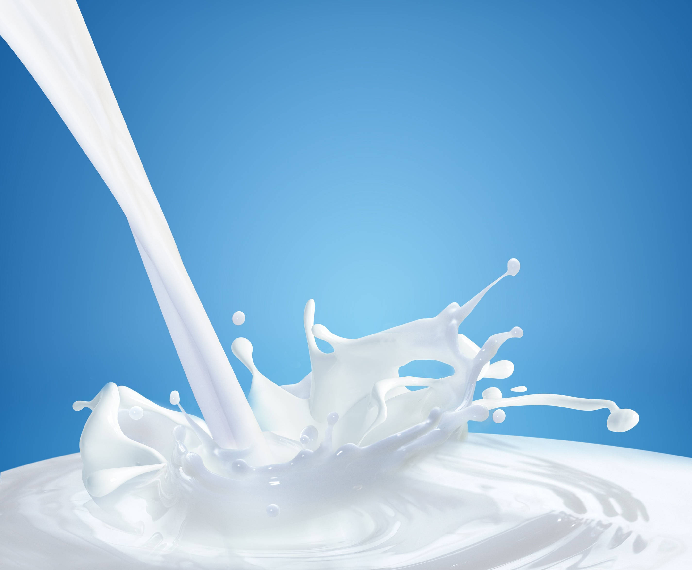 Milk 桌布 壁紙 — 一股動態的白色牛奶飛濺在純藍色背景上，創造出奶油般運動的凝固瞬間。