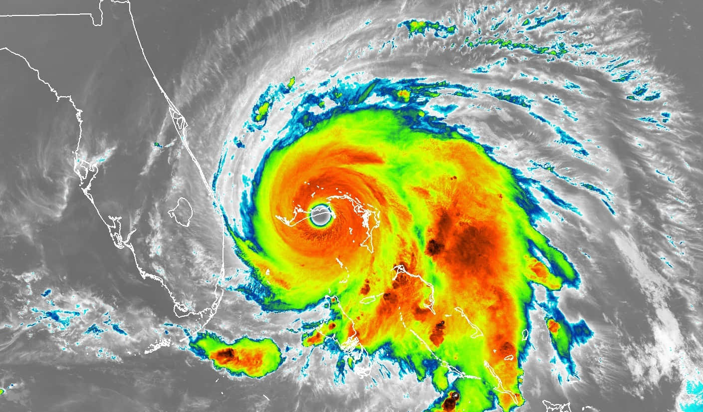 Hurricane 桌布 壁紙 — 一股強大的颶風在海洋上空旋轉，鮮豔的橙色和綠色帶環繞著海岸附近平靜的風眼。